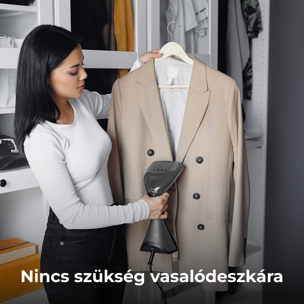 Nő egy bézs blézert gőzöl egy szekrényben, kézi gőzölővel.