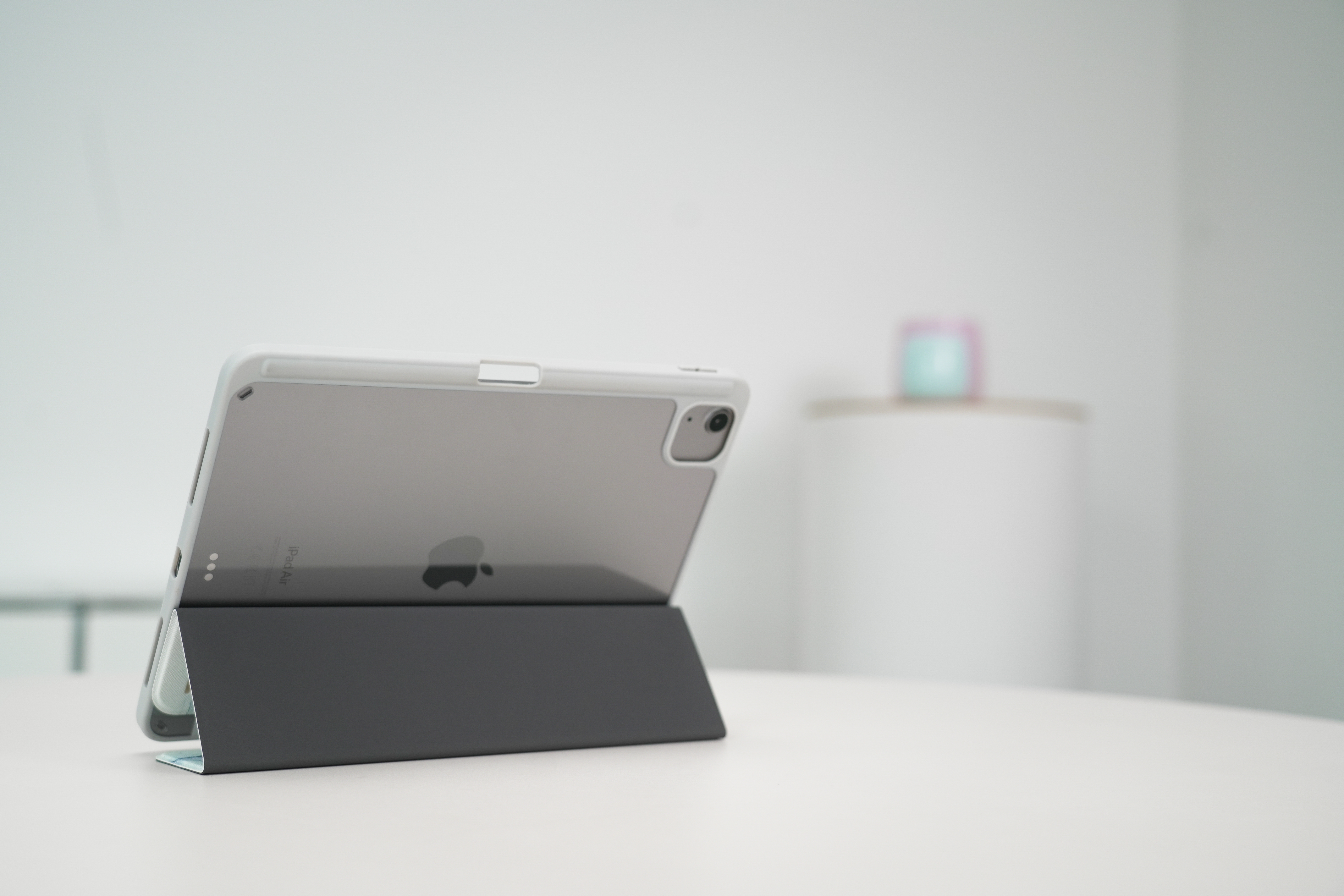 Ein geöffnetes Apple iPad in einem grauen Gehäuse auf einem weißen Tisch.
