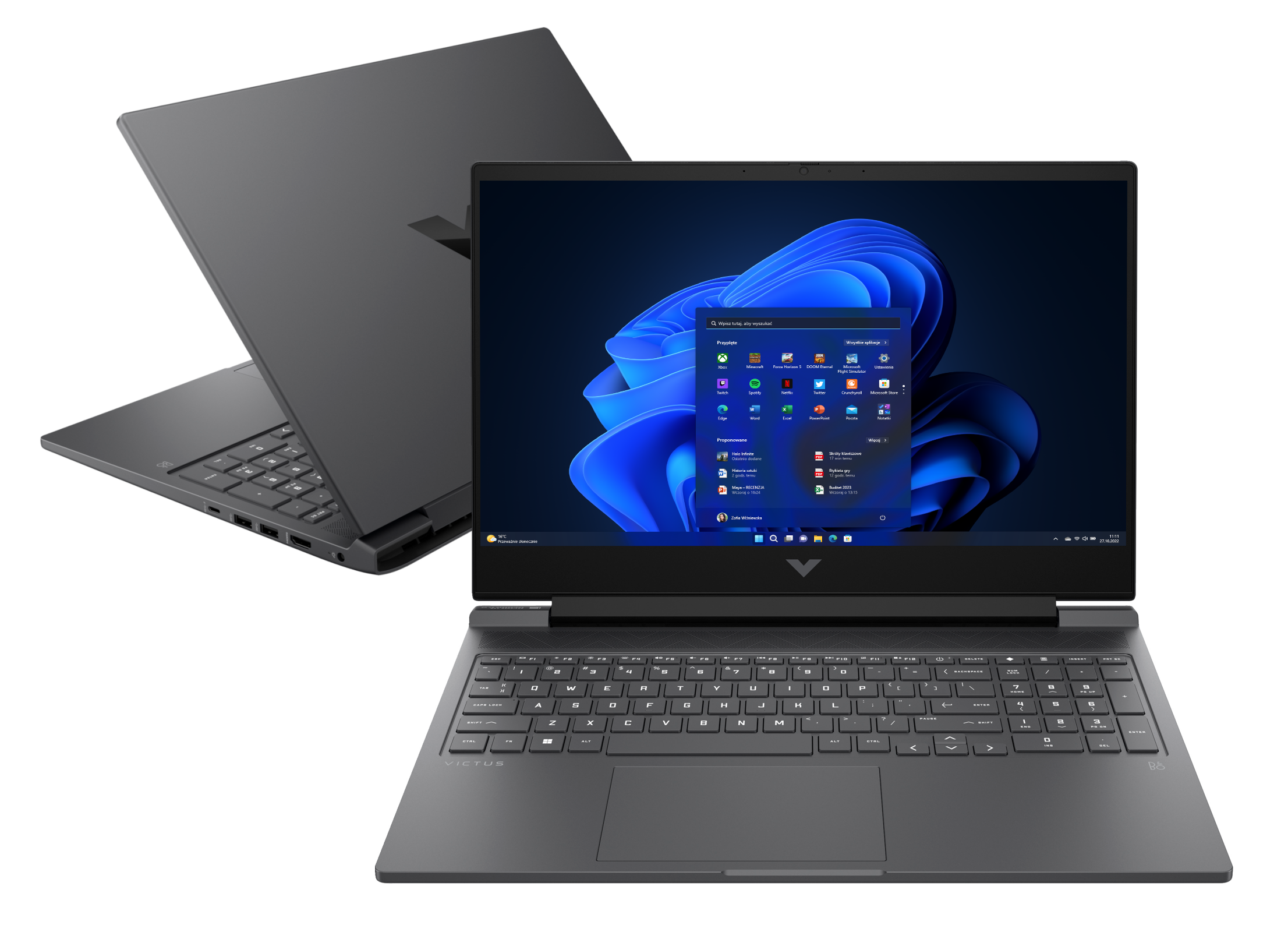 Laptop, czarny, otwarty na biurku. Widok z góry, pokazujący ekran z ikonami aplikacji.