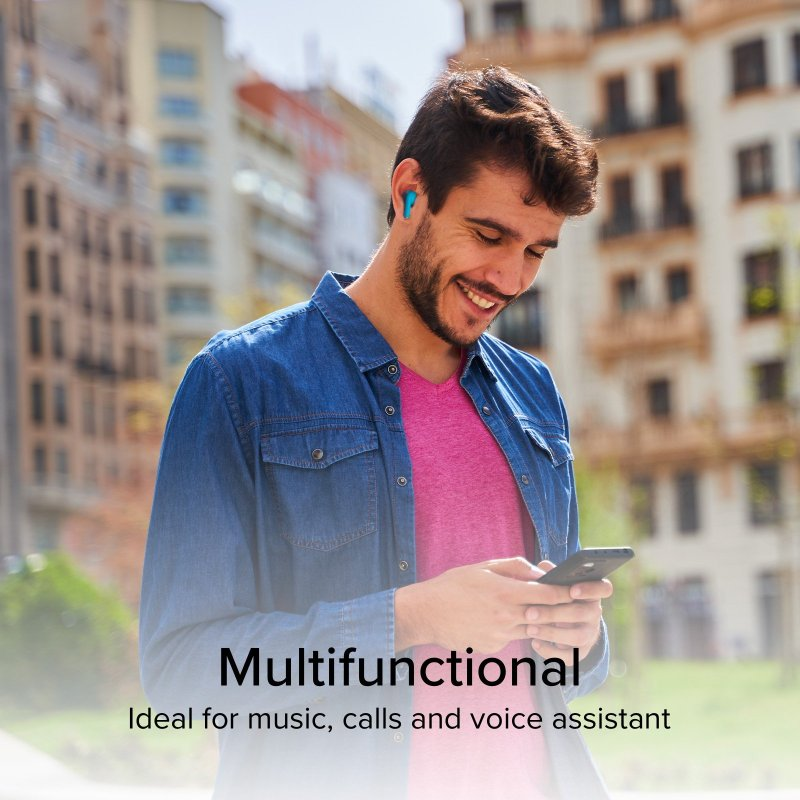 Ein Mann mit blauen Ohrhörern lächelt, während er draußen ein Telefon benutzt.