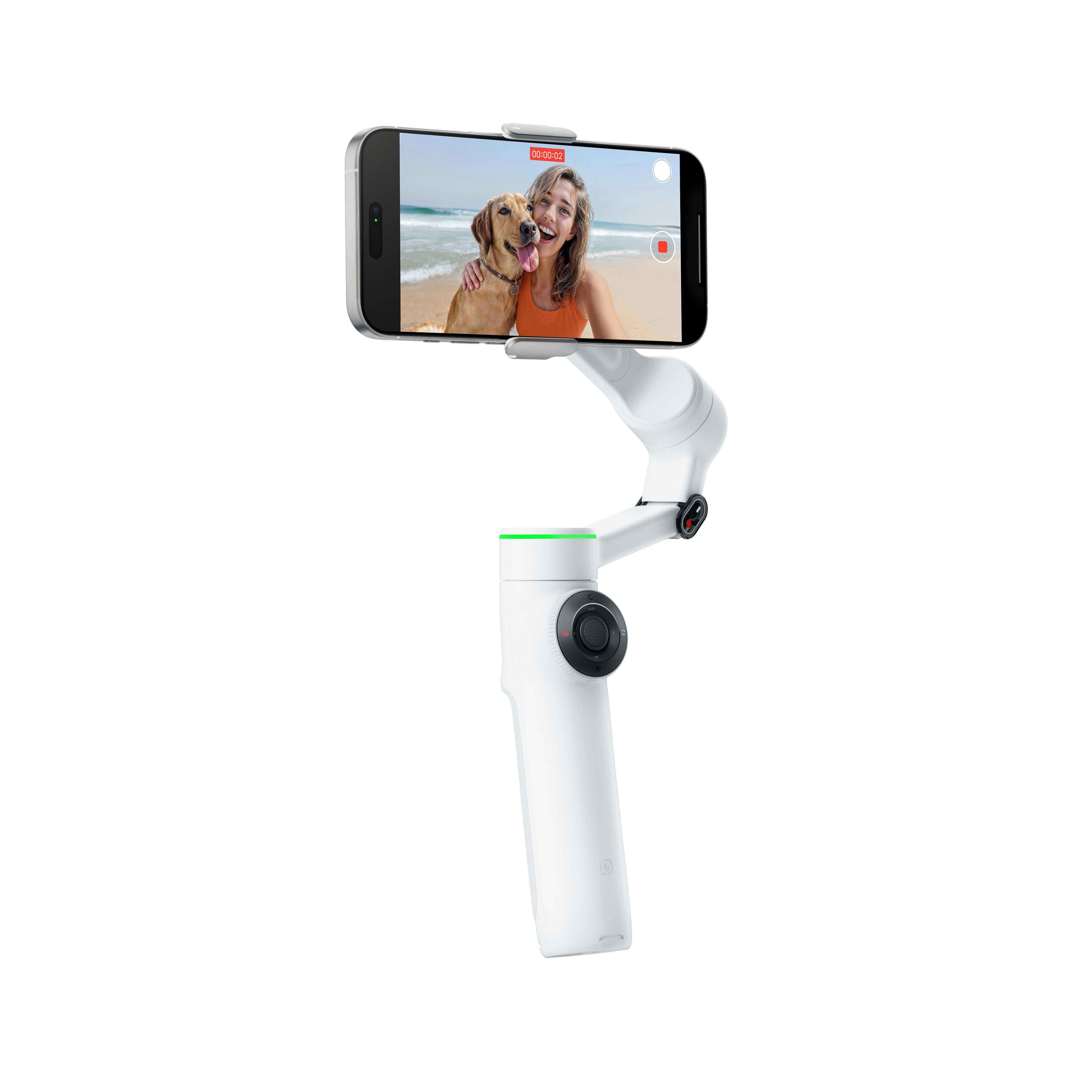 Weißes Gimbal mit Telefon, das ein Video am Strand mit Hund aufzeichnet.