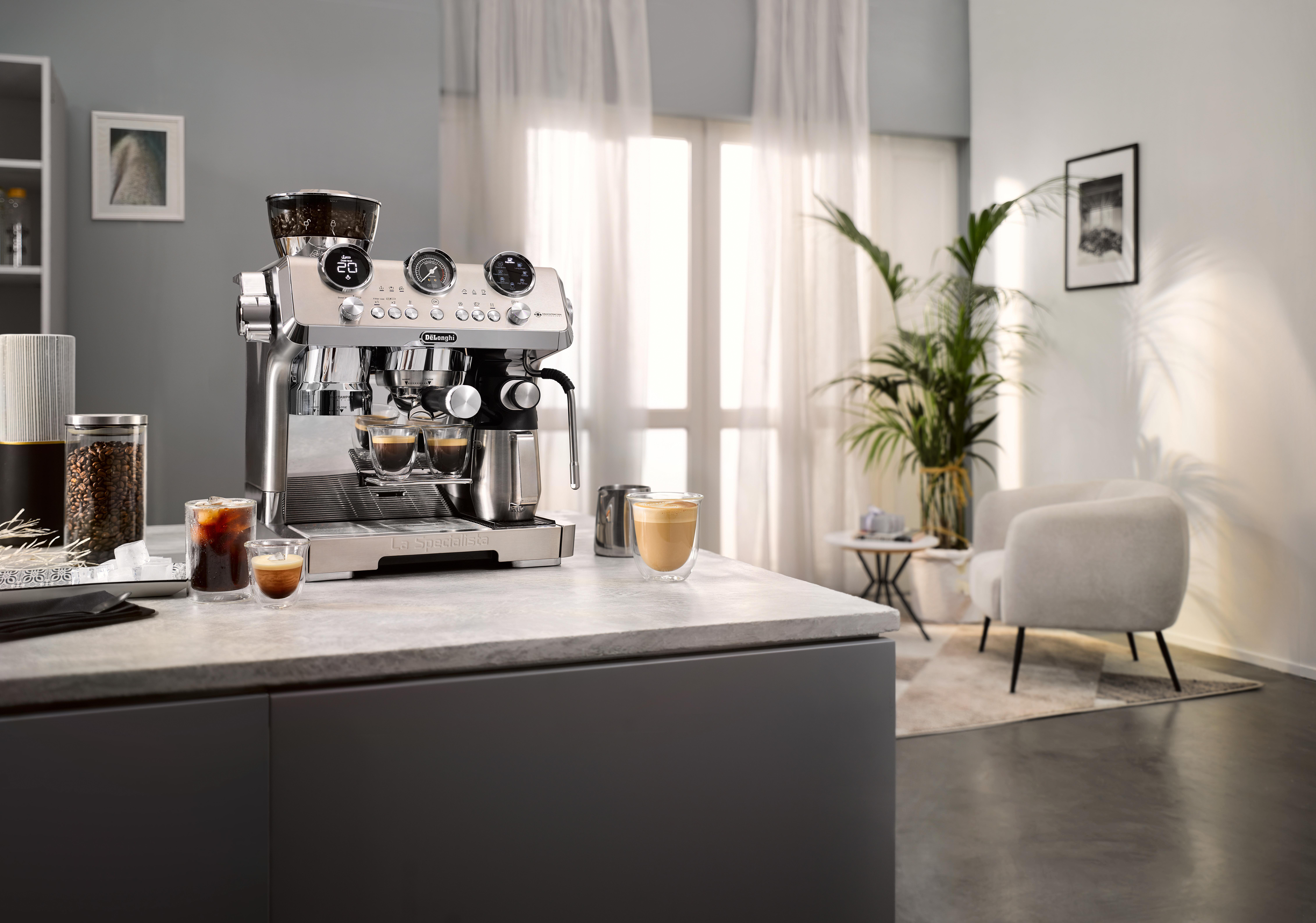Espressomaschine auf der Theke. Kaffeegetränke und Bohnen werden gezeigt. Modernes Wohnzimmer mit weißem Stuhl und Pflanze.