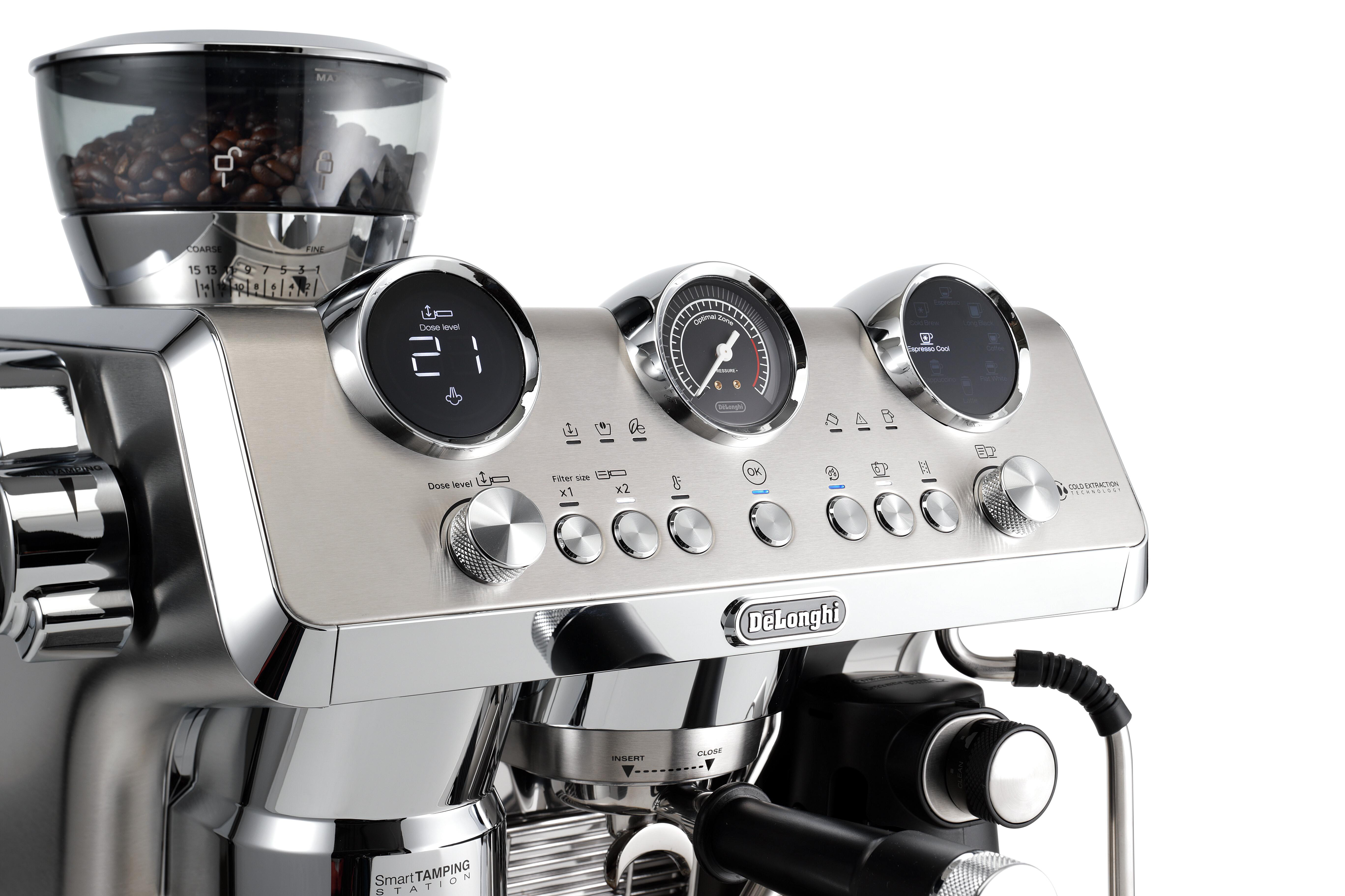 Eine silberne De'Longhi Espressomaschine. Sie hat eine Kaffeemühle, Zifferblätter und Knöpfe. Kaffeebohnen sichtbar.