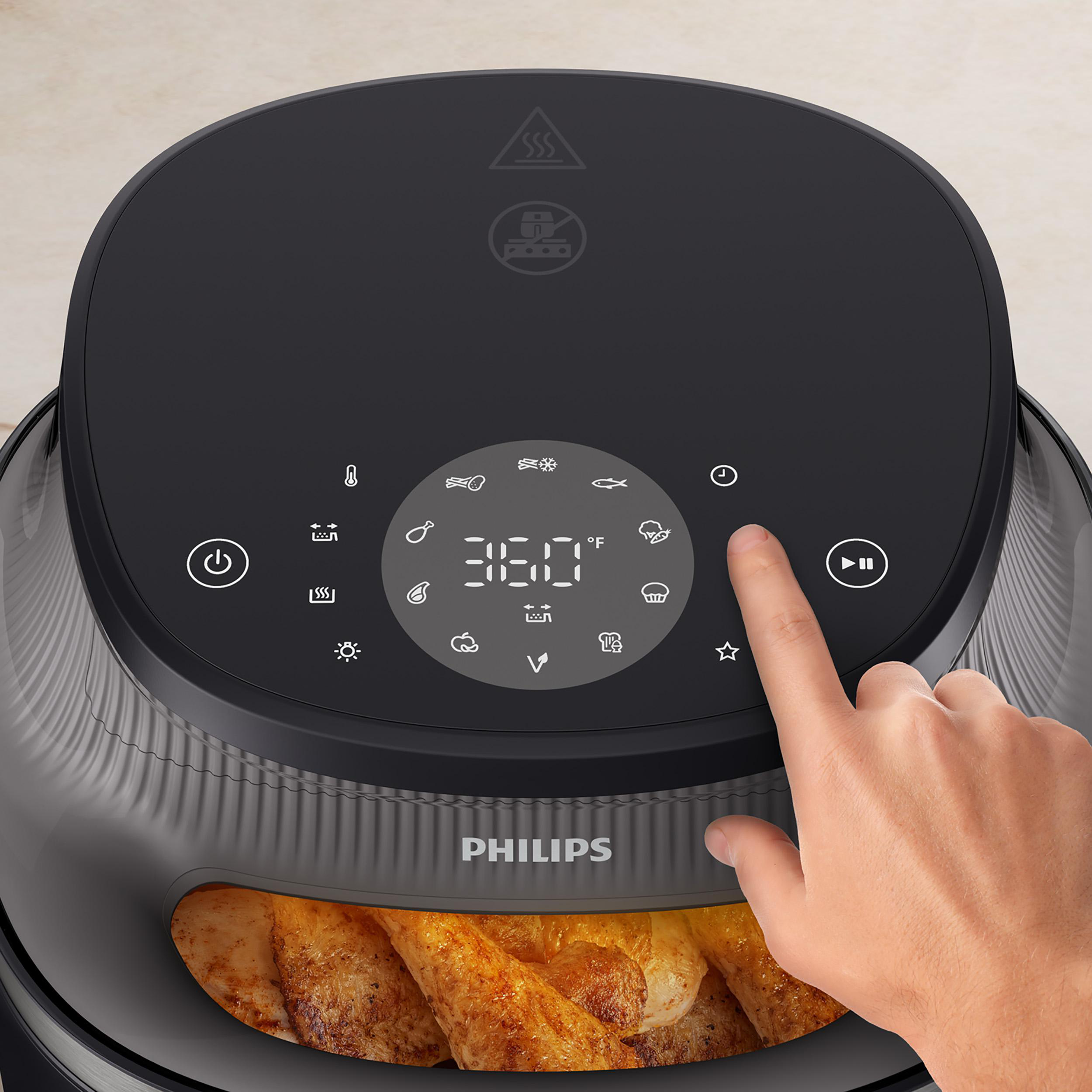 Nahaufnahme der Oberseite einer Heißluftfritteuse. Ein Finger drückt die Timer-Taste und zeigt 360 Grad an.