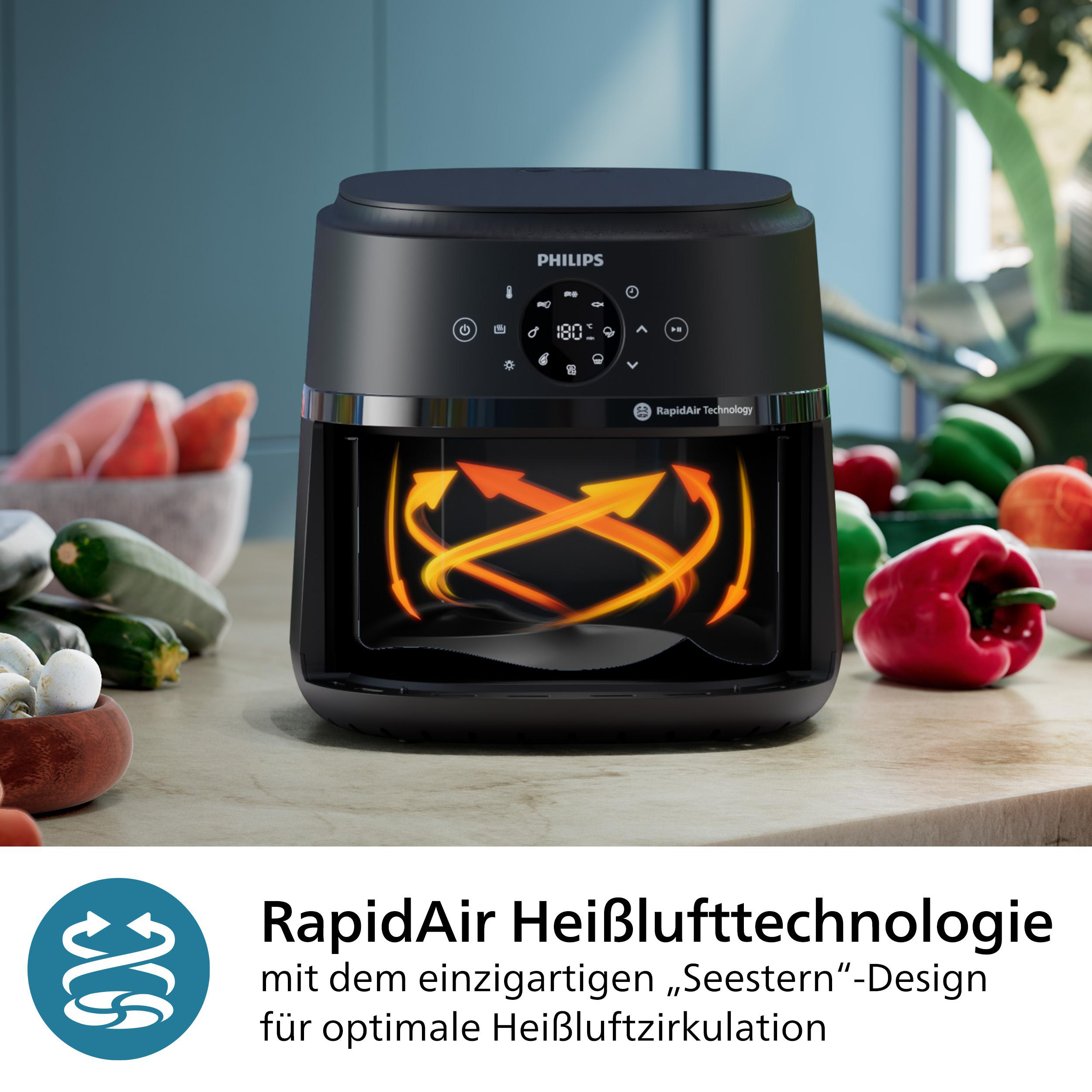 Schwarze Heißluftfritteuse mit orangefarbenen Pfeilen. Gemüse im Hintergrund.