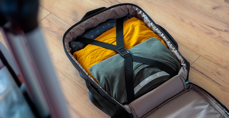 Otwarta walizka z ubraniami. Widoczne żółte i szare koszule.