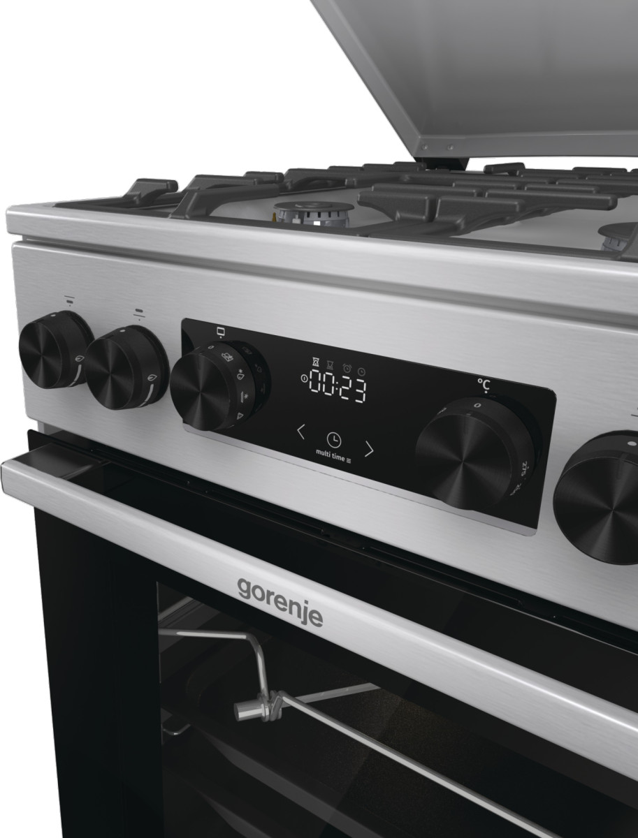 Zbliżenie piekarnika ze stali nierdzewnej z czarnymi pokrętłami i wyświetlaczem '00:23'.