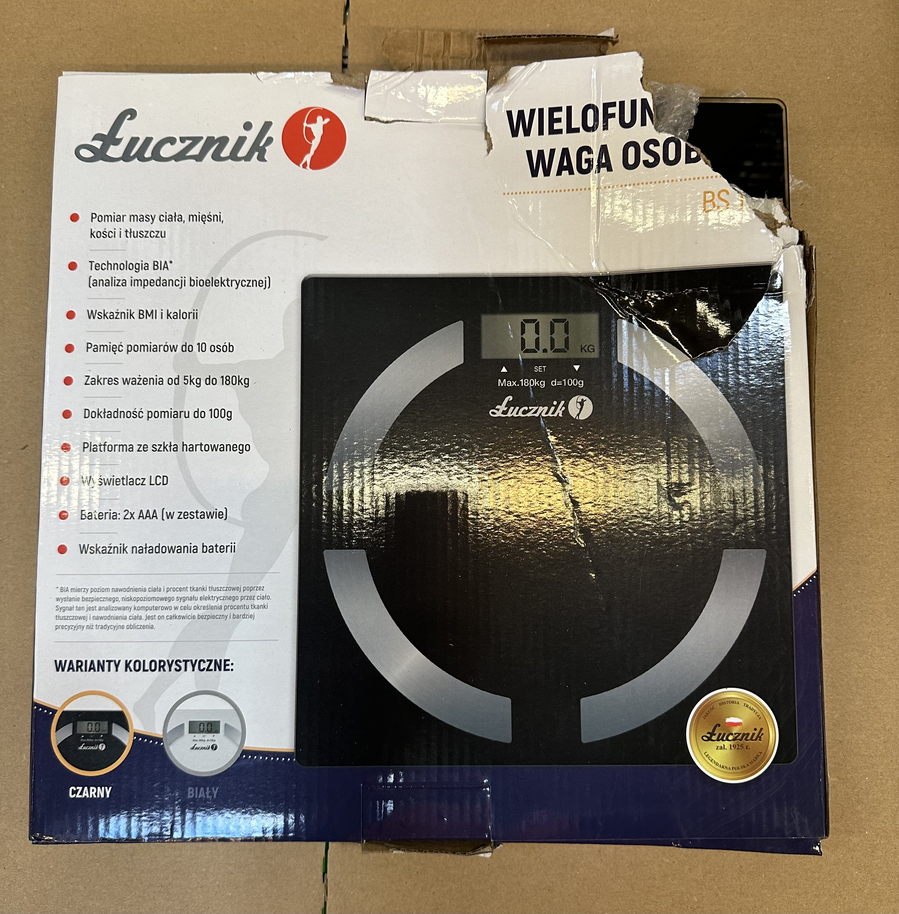 Pudełko wagi łazienkowej, marka Lucznik, czarne z białym tekstem.