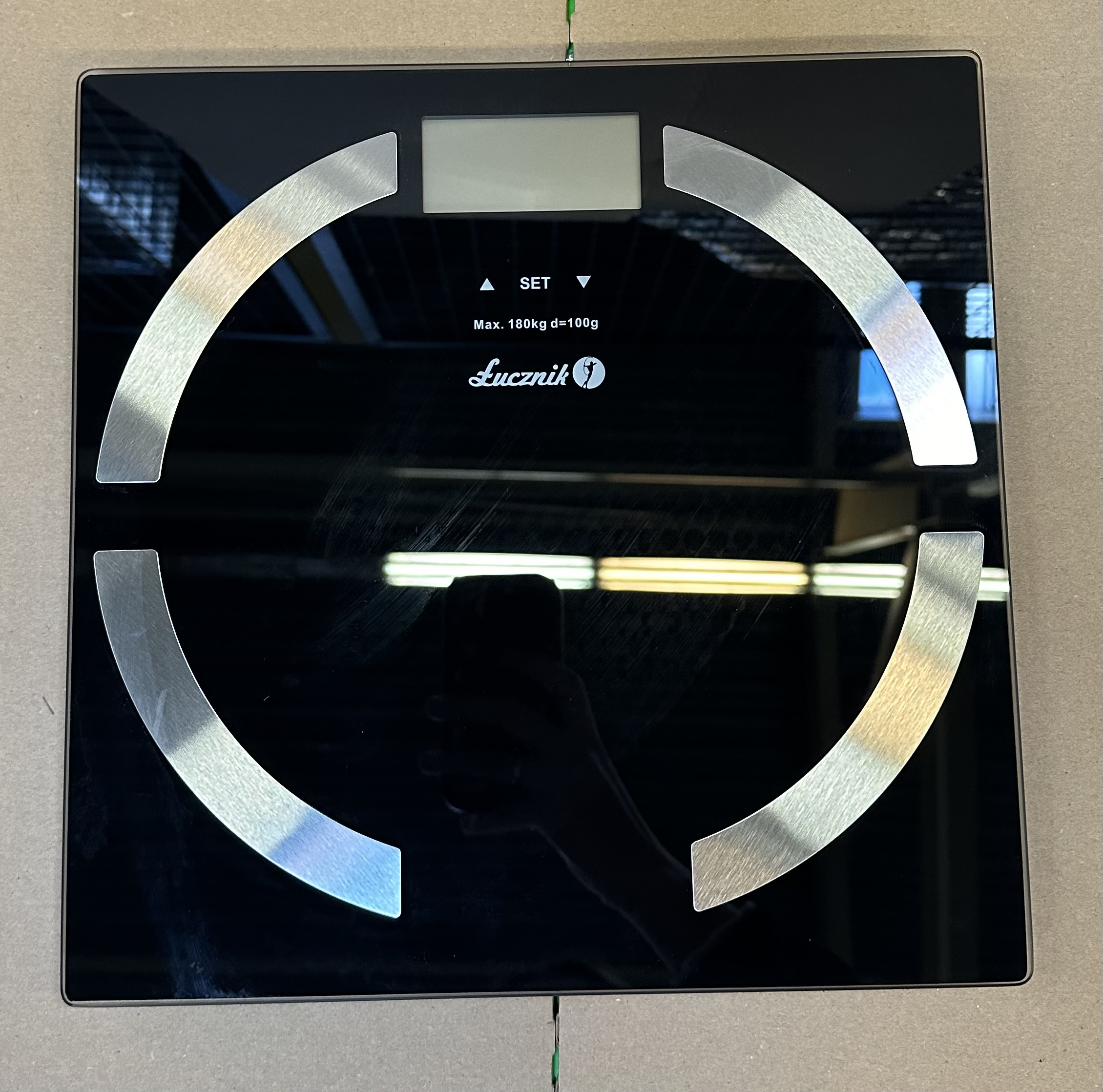 Czarna cyfrowa waga łazienkowa. Wyświetla wagę. Srebrne wykończenie. Czarne tło.