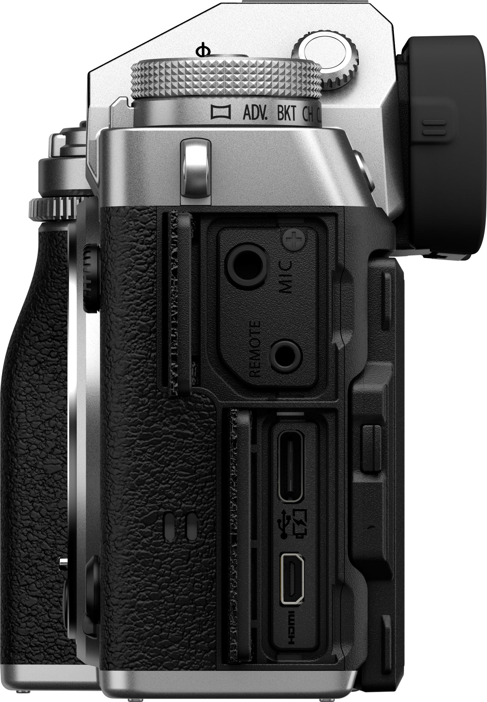 Vista laterale di una fotocamera argento e nera, con ghiere, porte per microfono, telecomando e HDMI.