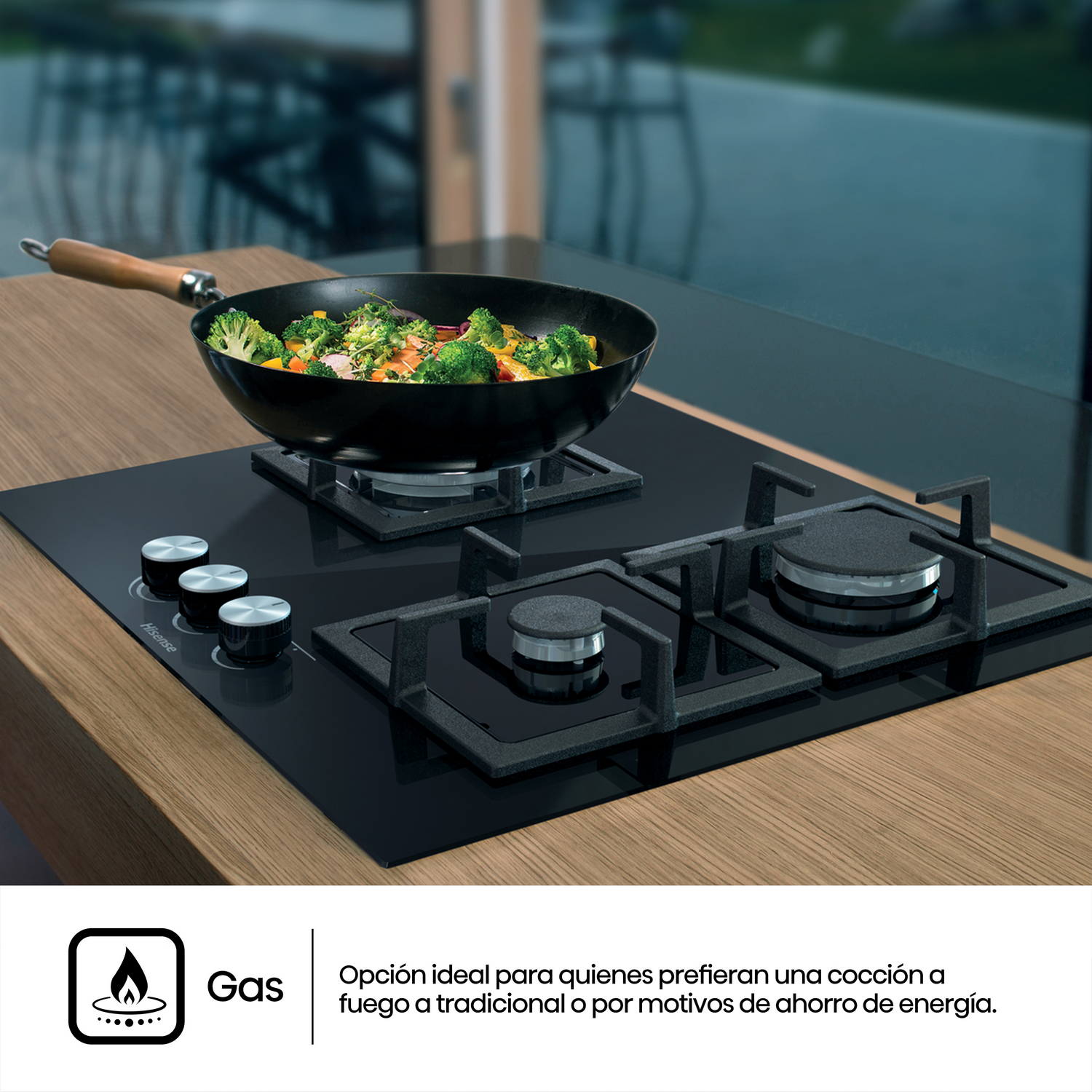 Una vitrocerámica negra con una sartén con comida cocinada y un texto sobre la cocina a gas. Encimera de madera.