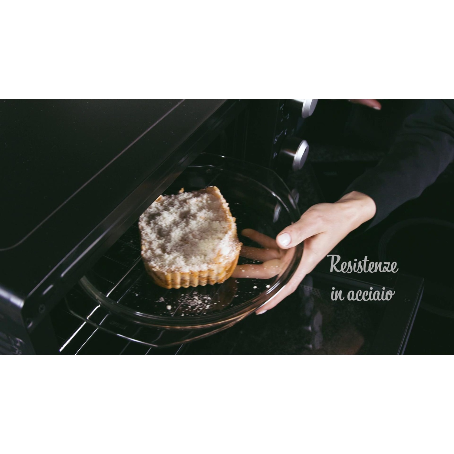 Mani che mettono una torta nel forno. Piatto di vetro. Testo sugli elementi in acciaio inox.