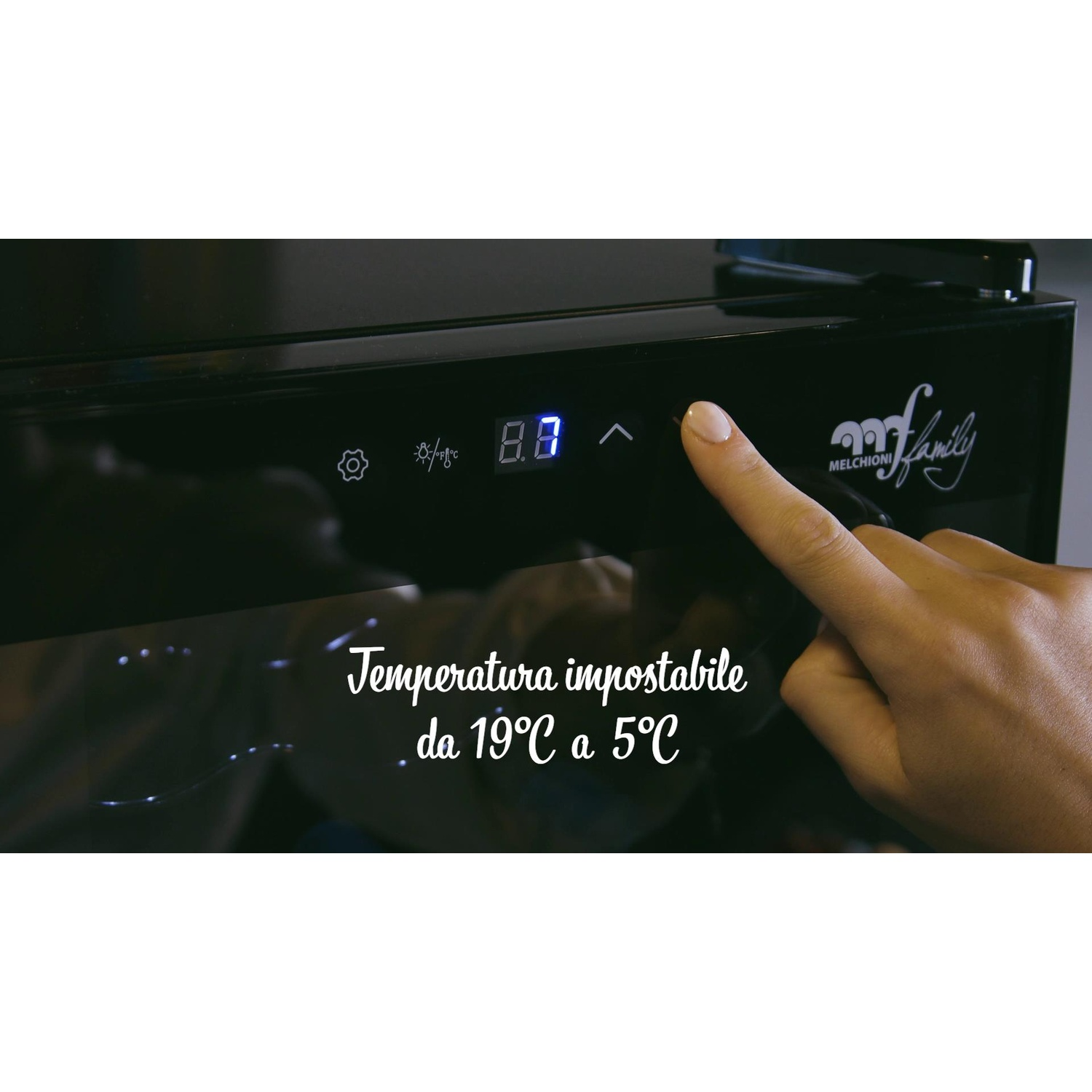 Una mano preme un pulsante su una cantinetta con display digitale.