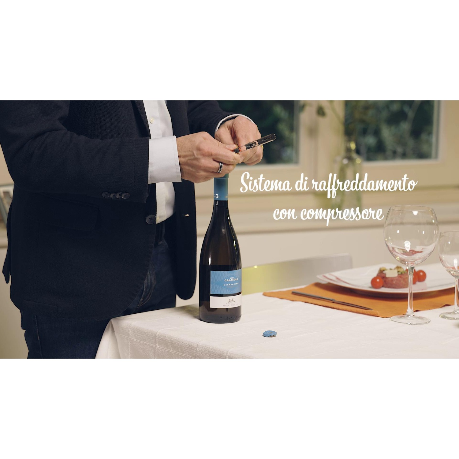 Una persona che apre una bottiglia di vino a un tavolo con bicchieri.