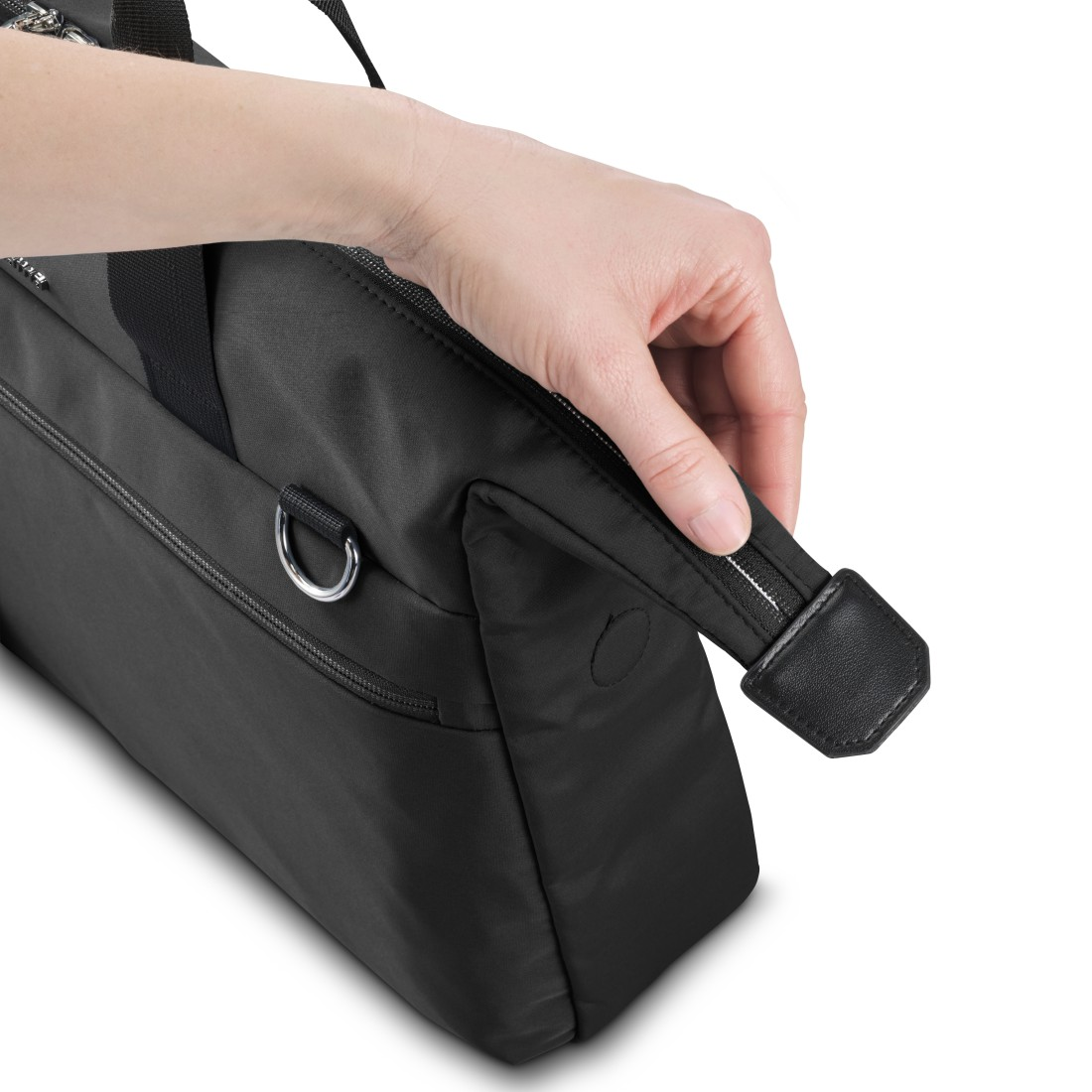 Eine Hand, die einen schwarzen Taschenriemen hält. Die Tasche ist schwarz.