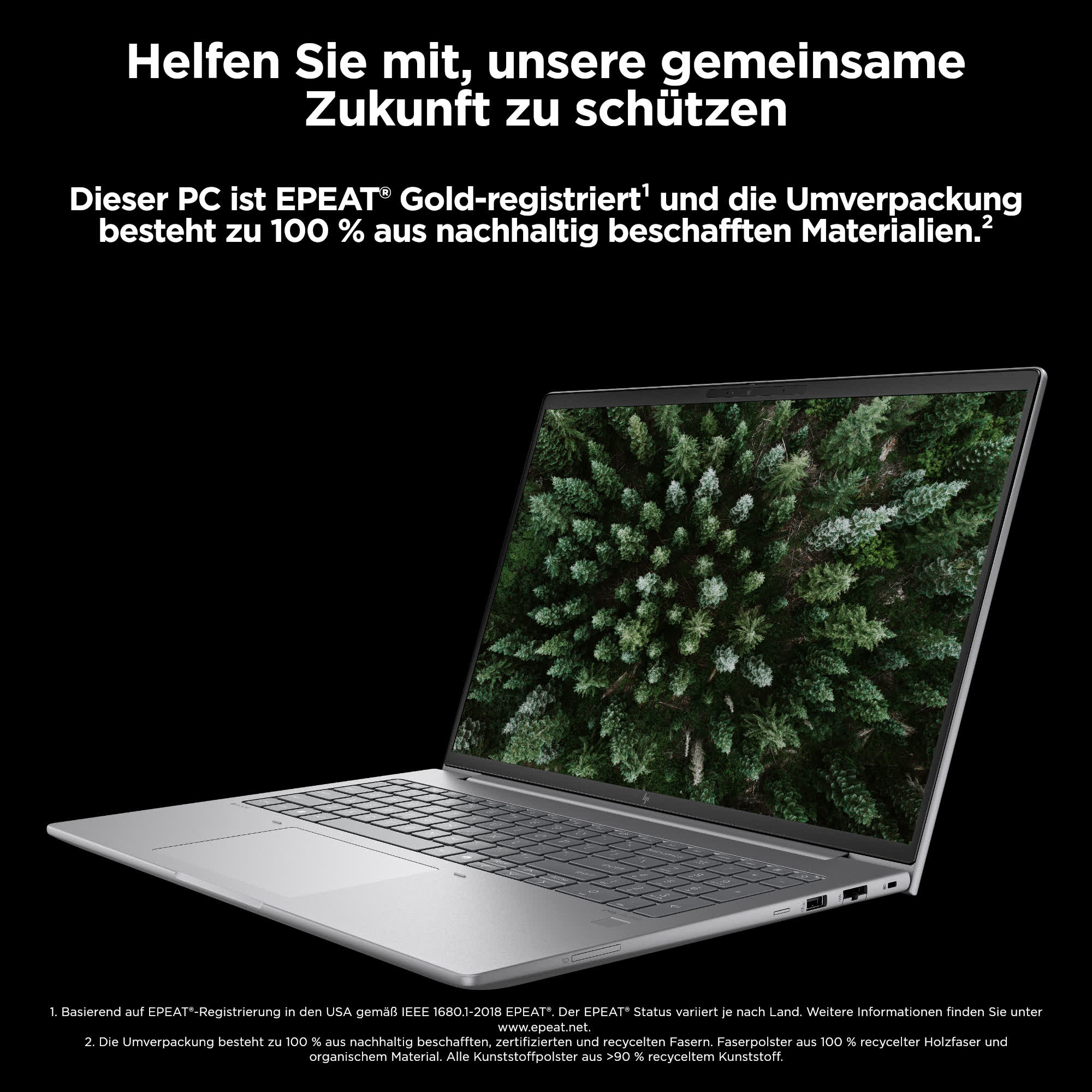 Laptop auf einem Tisch mit einem Wald-Bild auf dem Bildschirm und Text auf Deutsch.