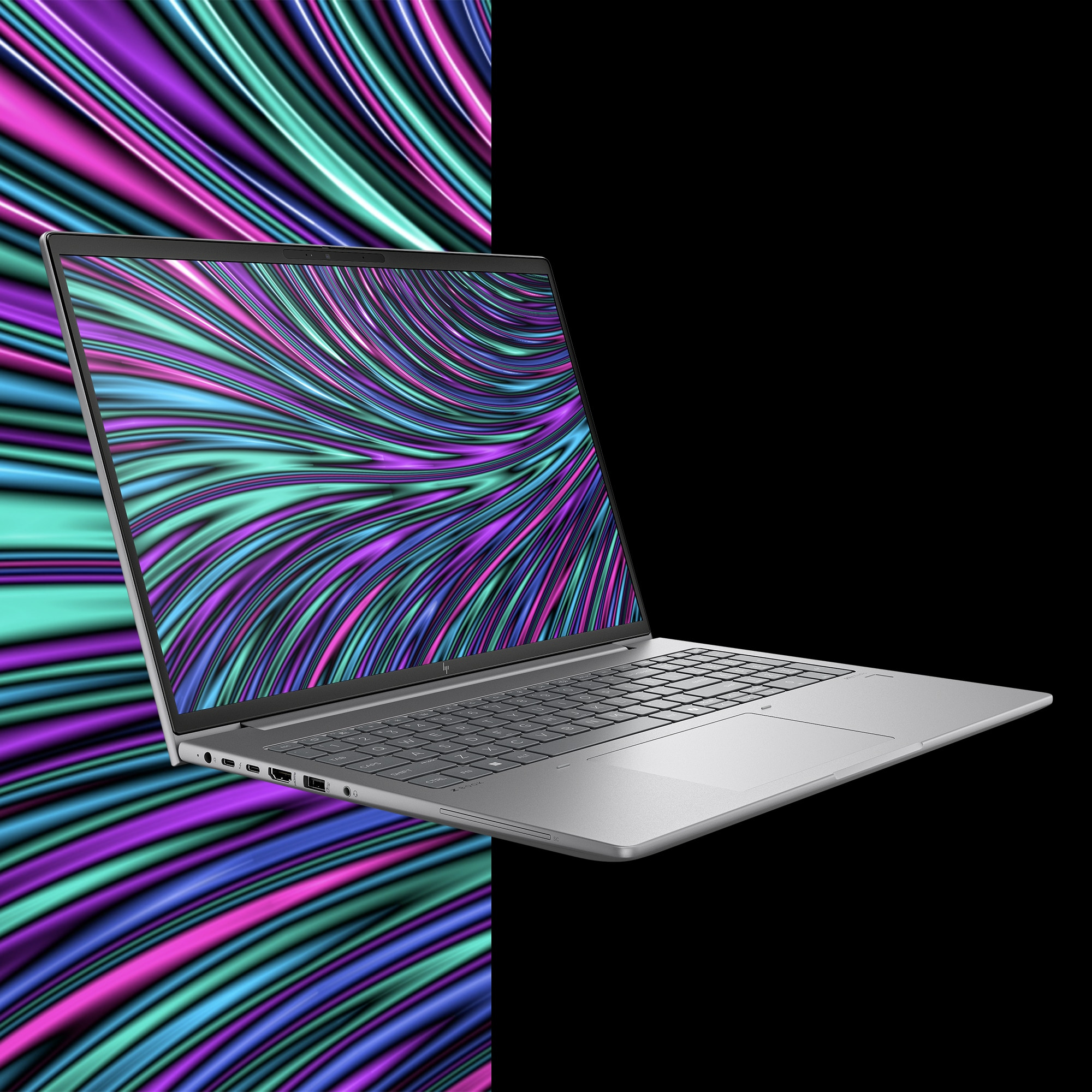 Silberner Laptop mit farbenfrohem Wellendesign auf dem Bildschirm, vor schwarzem Hintergrund.