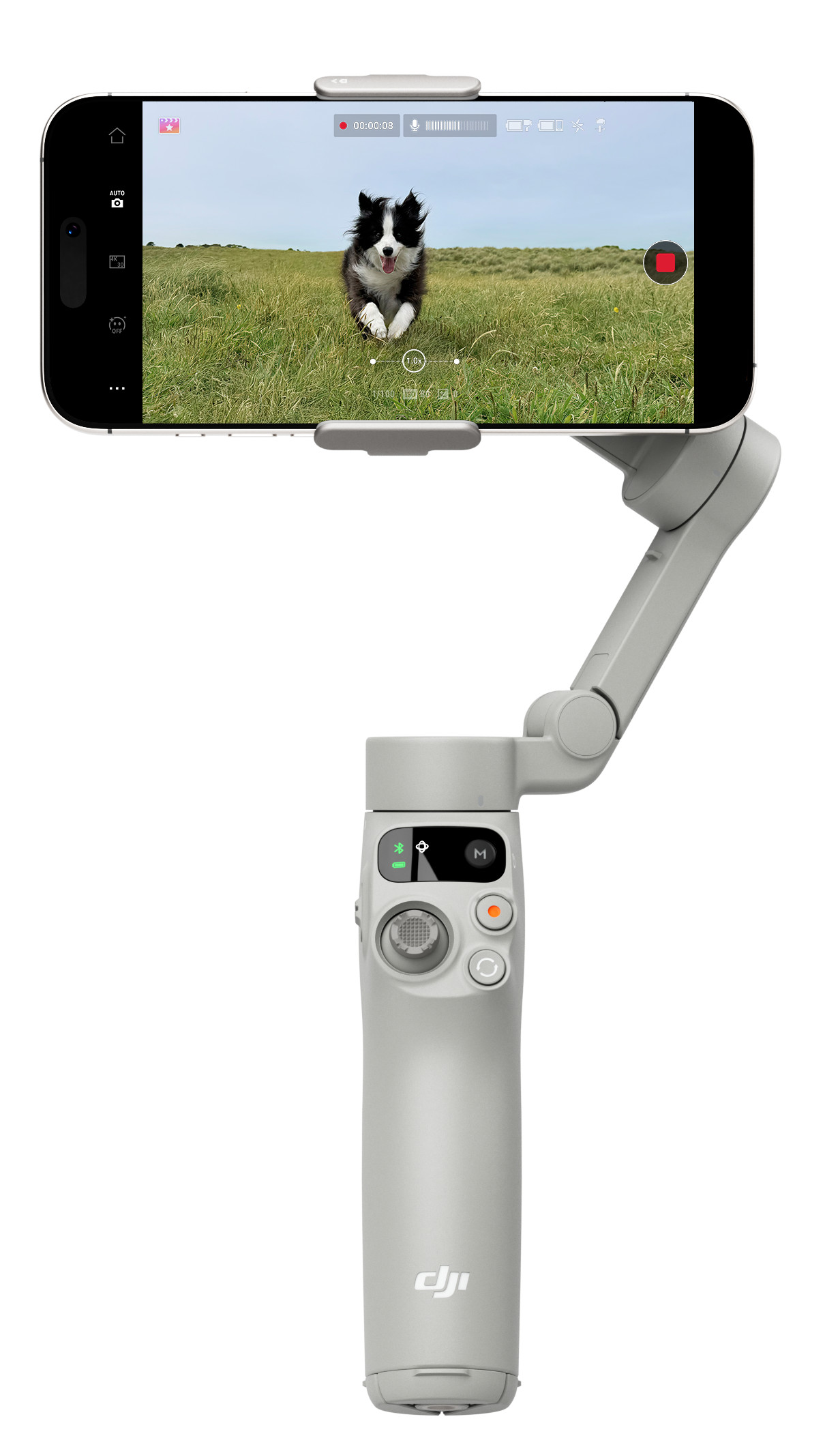 Biały gimbal ręczny z dołączonym telefonem, pokazujący psa biegnącego po trawie.