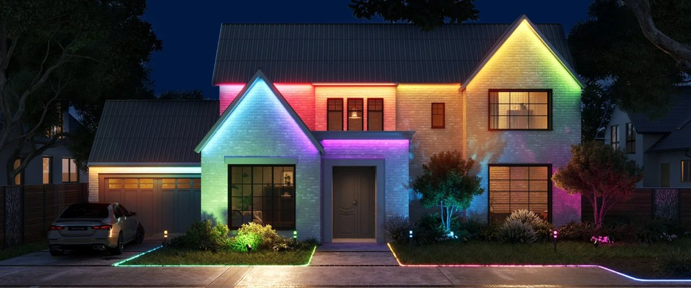 Dom nocą z kolorowymi światłami na dachu i ścieżce.