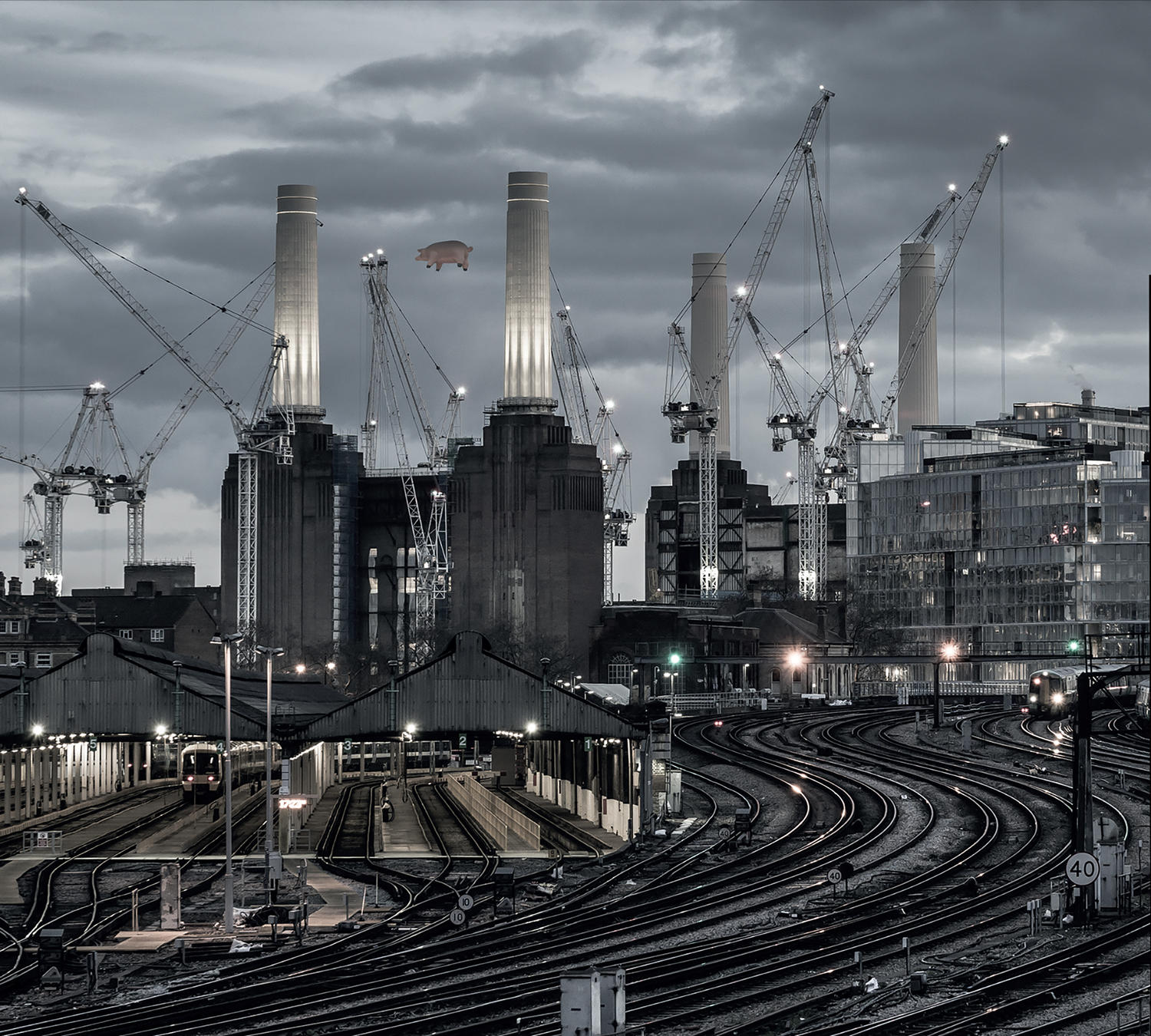Eine Stadtlandschaft mit Bahngleis und einem rosa Schwein, das am Himmel schwebt.