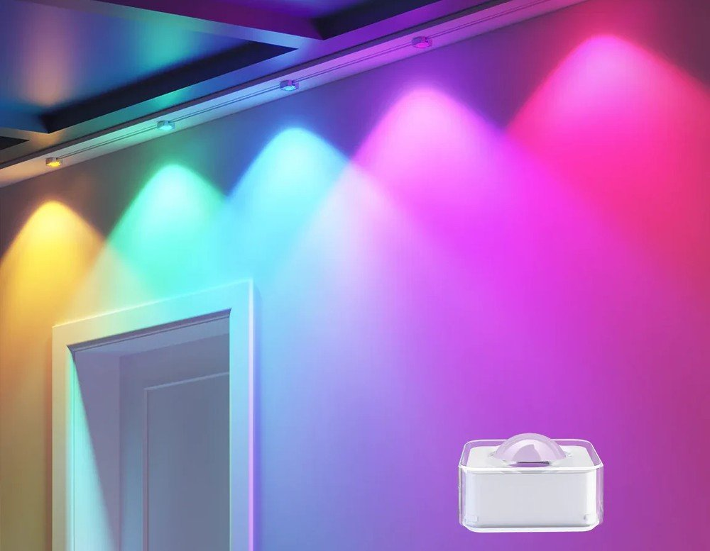 Wnętrze z kolorowymi reflektorami. Białe drzwi, białe i różowe ściany, białe kwadratowe urządzenie.