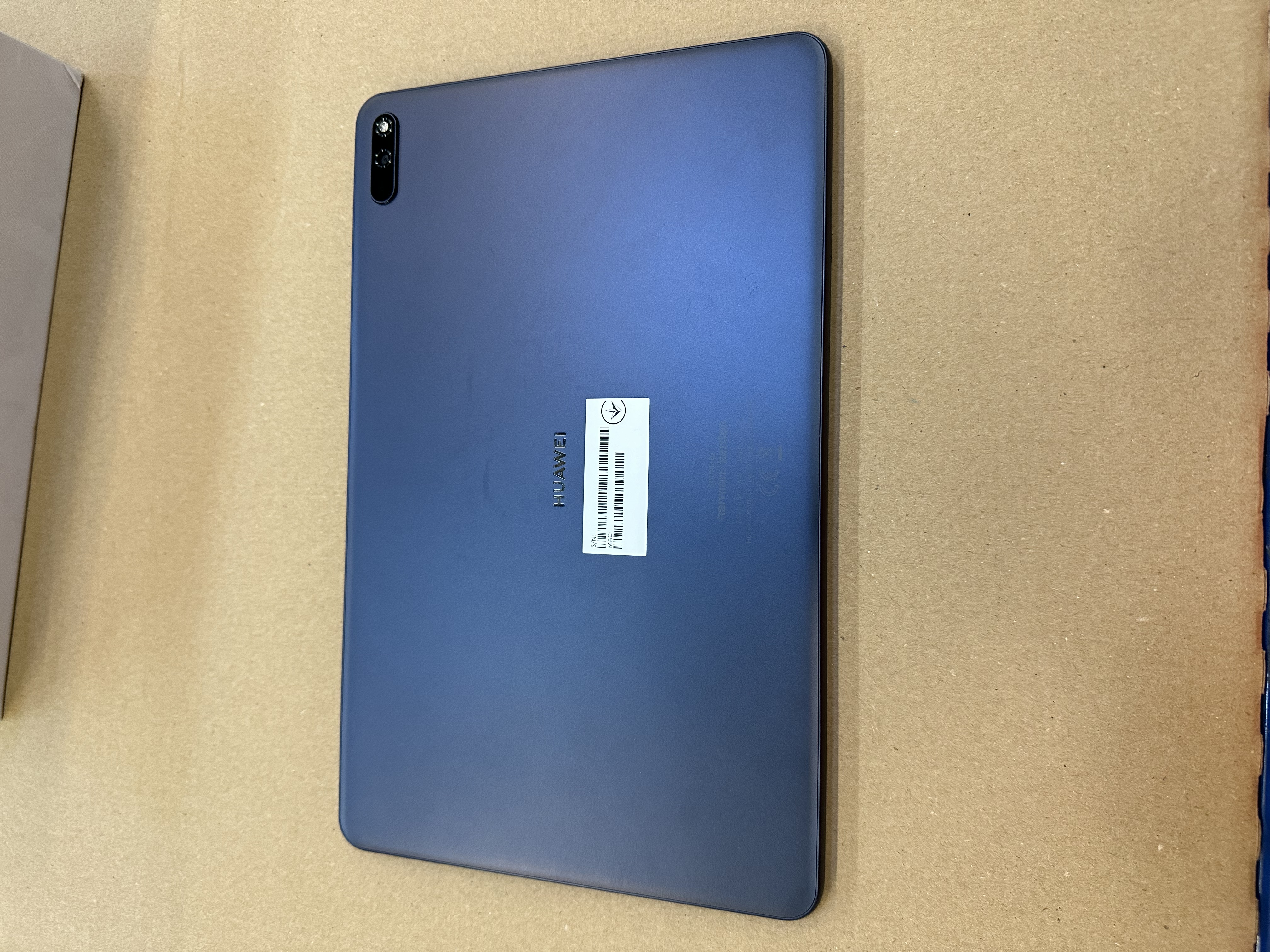 Ciemnoniebieski tablet Huawei z tylnym aparatem i etykietą.