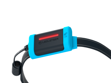 Zbliżenie niebieskiej latarki czołowej LED LENSER, pokazujące światło i logo LED LENSER.