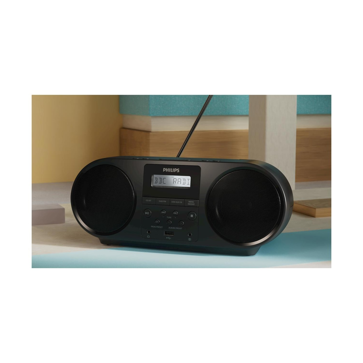 Radio boombox nera con due altoparlanti e display digitale. È su una superficie blu.