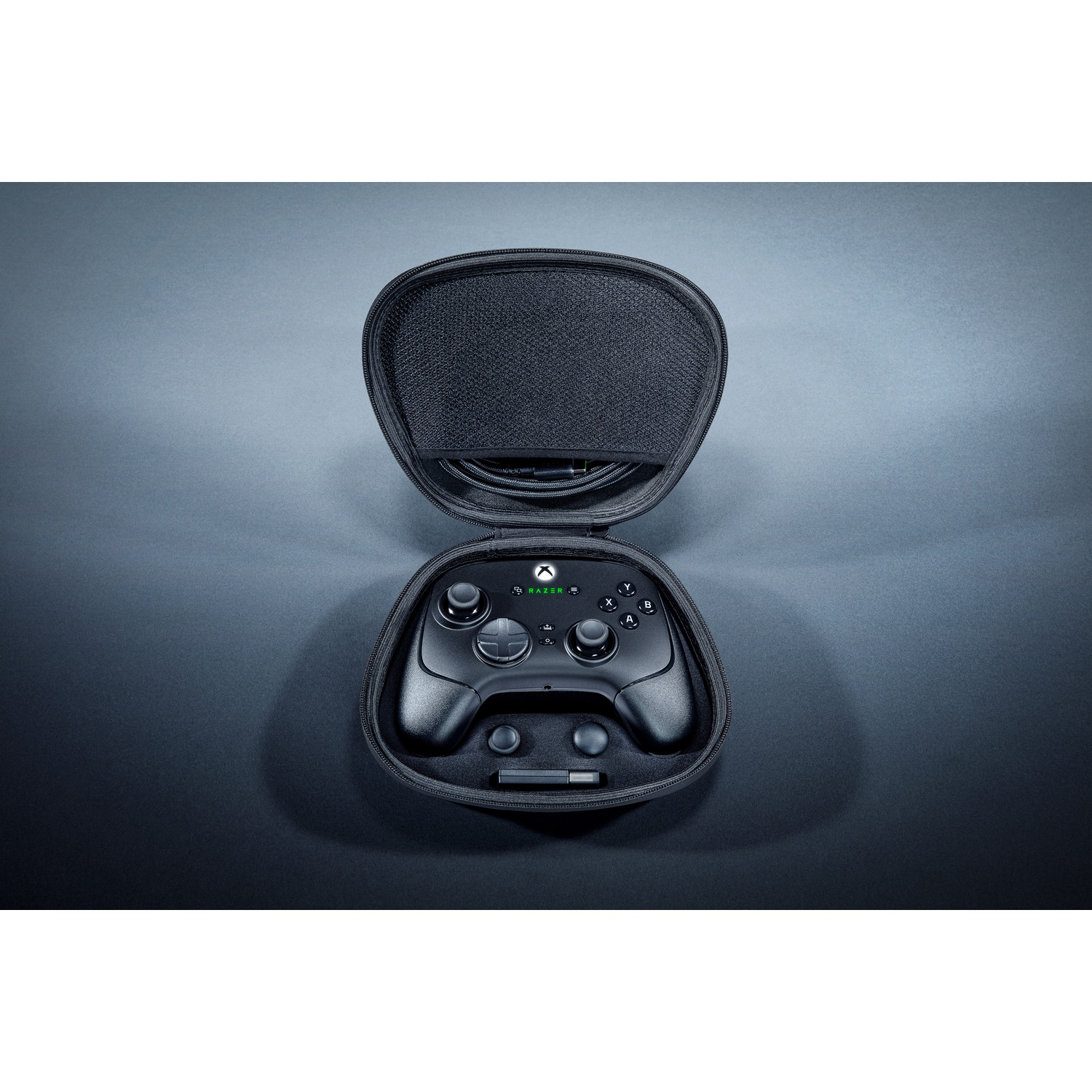 Black controller inside a case. The case is open. Dark grey surface.