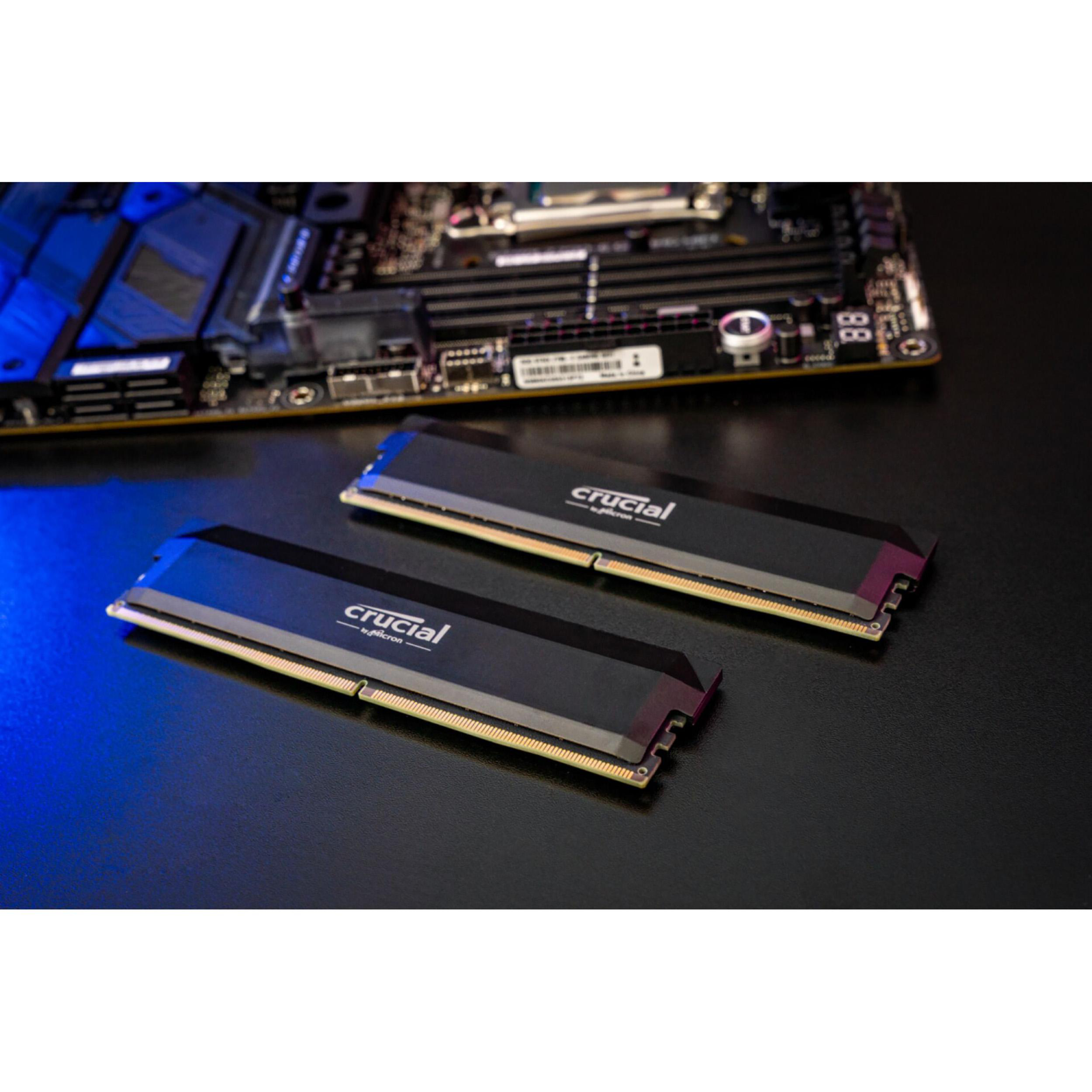 Zwei schwarze RAM-Riegel auf dunkler Oberfläche mit Mainboard. Blaues Licht.