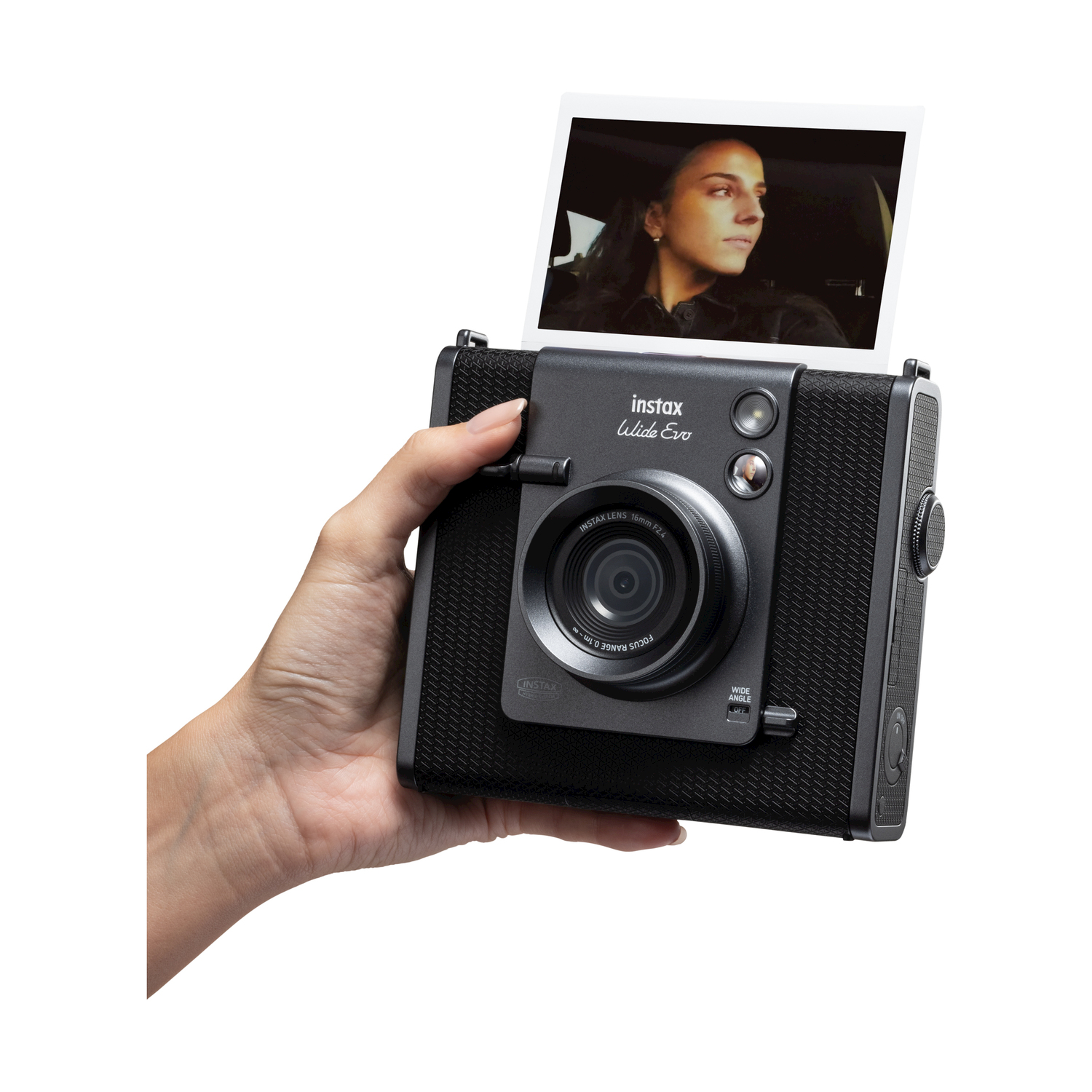 Una persona tiene in mano una fotocamera Instax nera che sta stampando un'immagine di una donna.