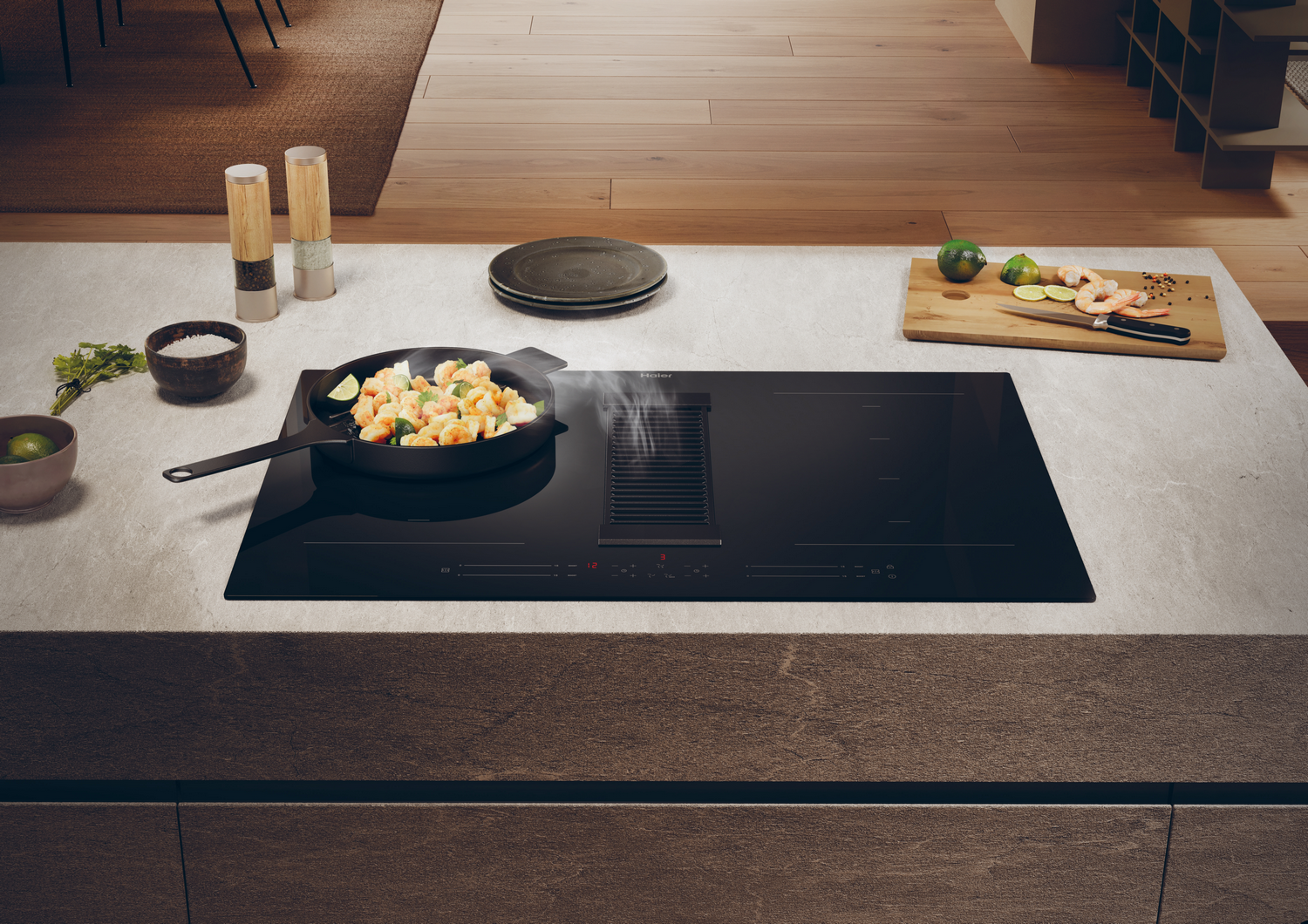 Escena de cocina con placa negra con extractor integrado, sartén con comida.