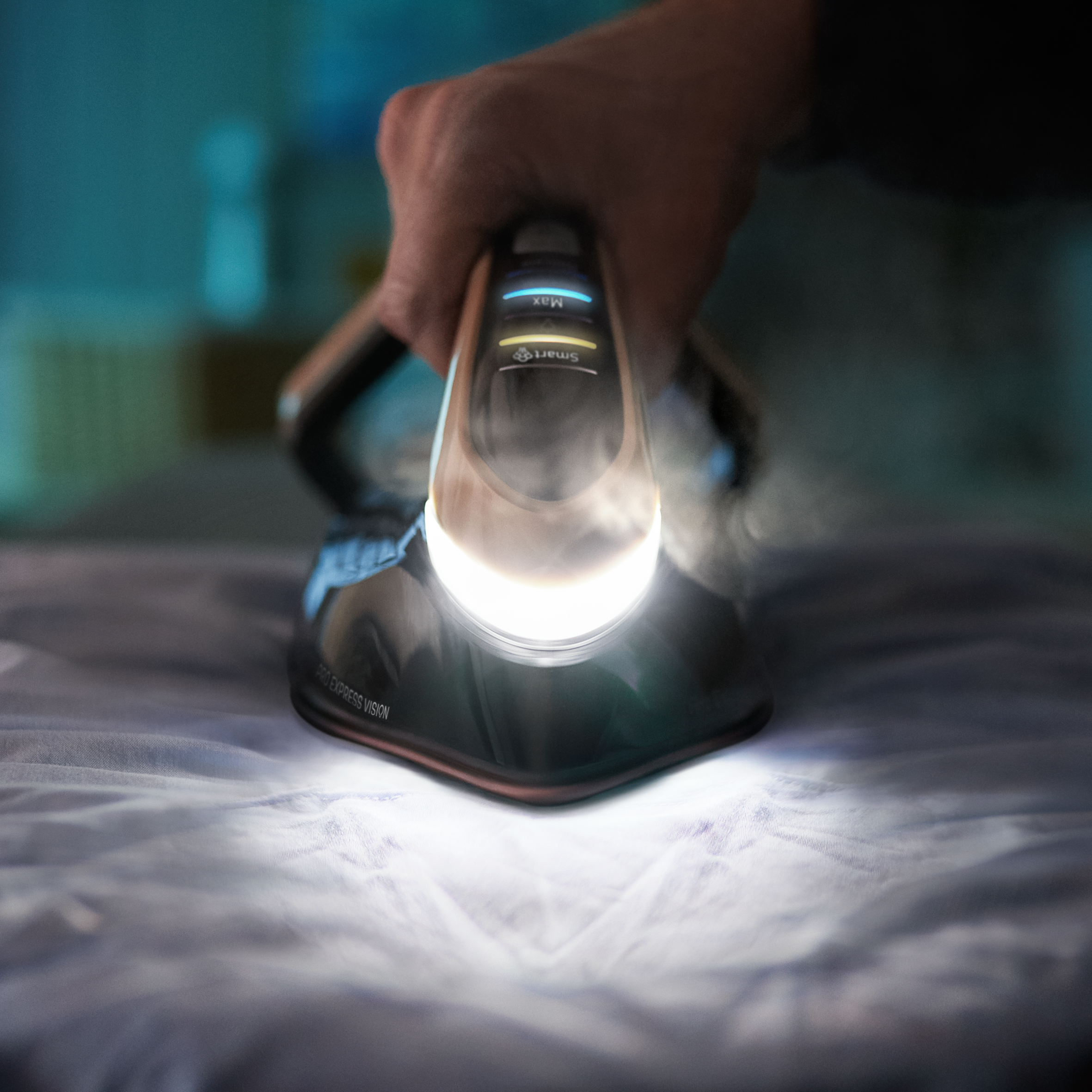 Zbliżenie żelazka na tkaninie, z parą i ręką w ostrości.