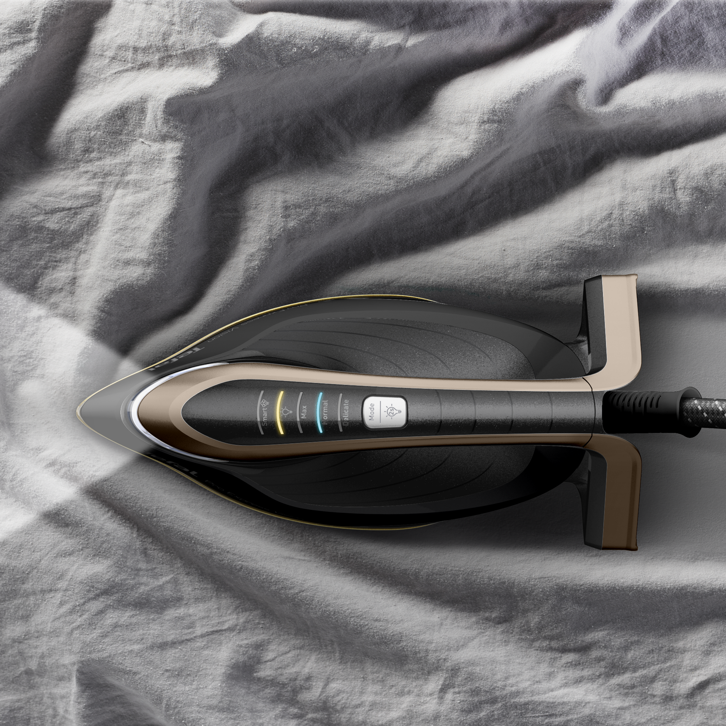 Czarne i złote żelazko na szarej tkaninie. Promień światła świeci. Przyciski są widoczne.