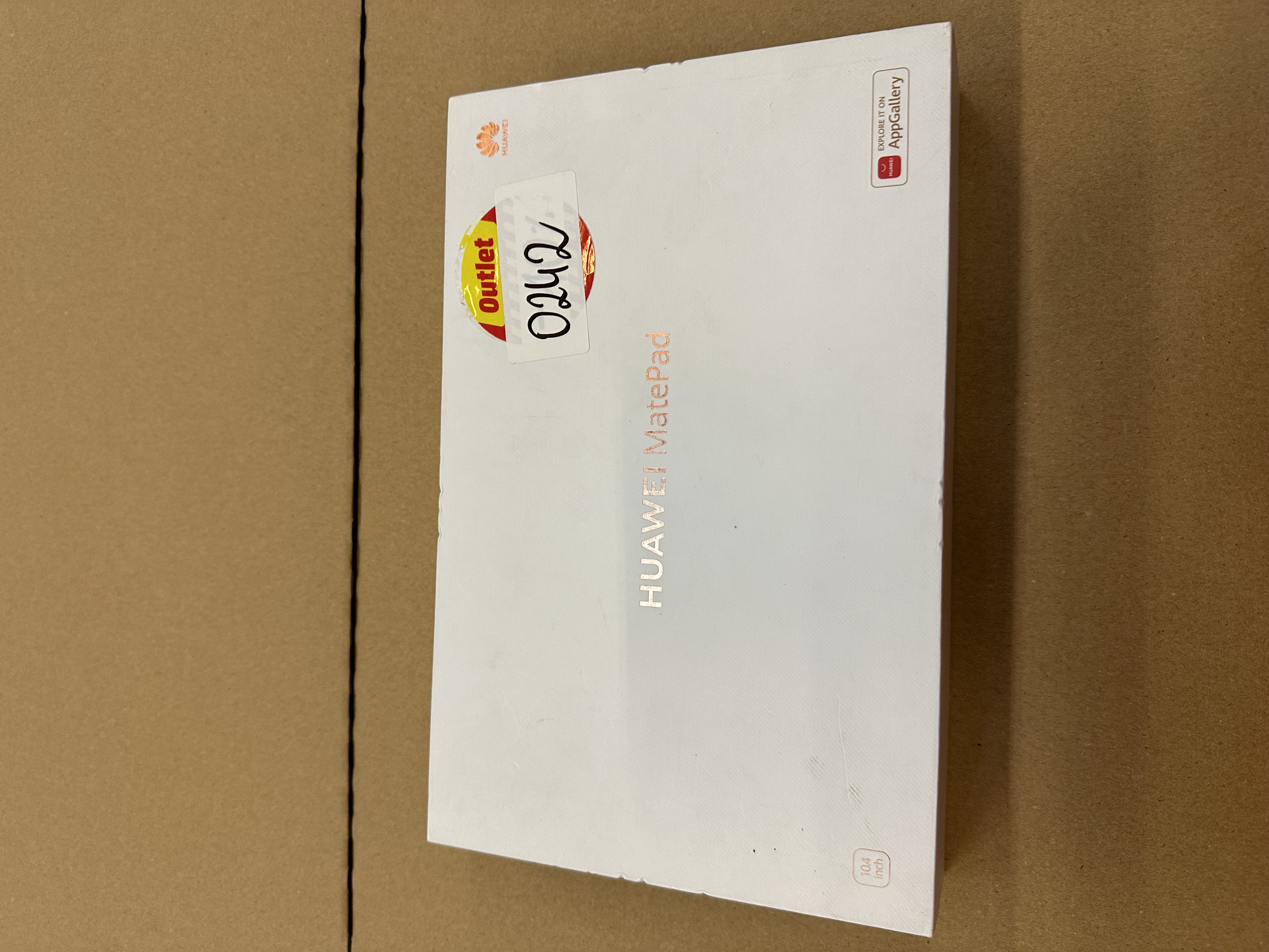Białe pudełko z napisem 'HUAWEI MatePad'. Naklejka Outlet z numerem 0242.
