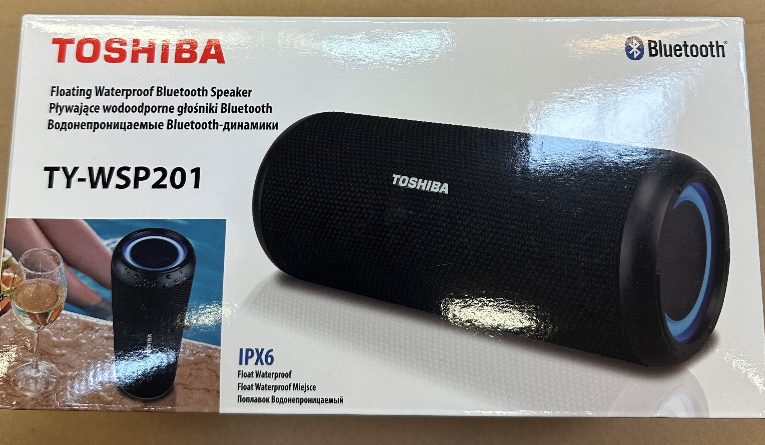 Czarny, wodoodporny głośnik Bluetooth Toshiba na pudełku. Głośnik ma kształt cylindryczny i niebieskie światło.