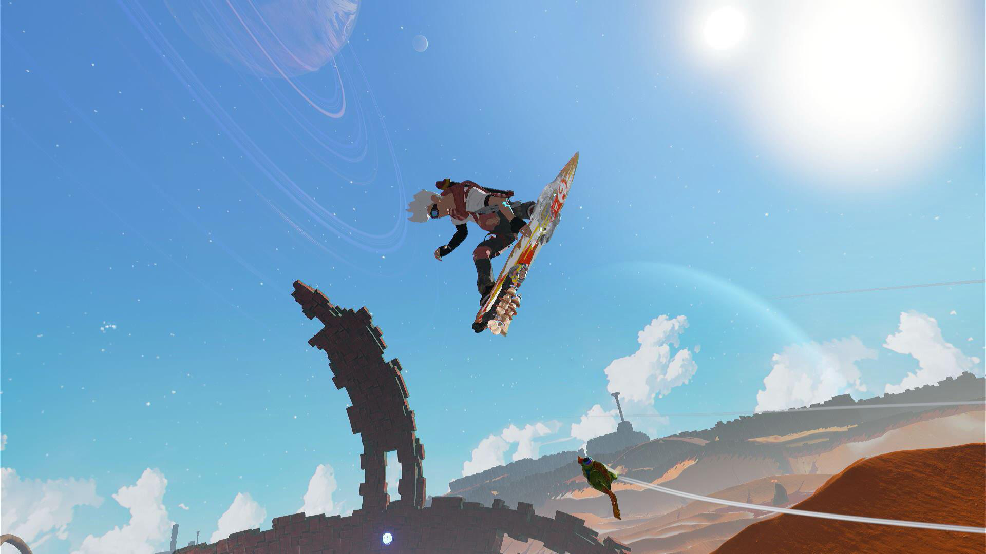 Ein Snowboarder springt in die Luft, mit einem Hintergrund aus blauem Himmel und einer entfernten Landschaft.