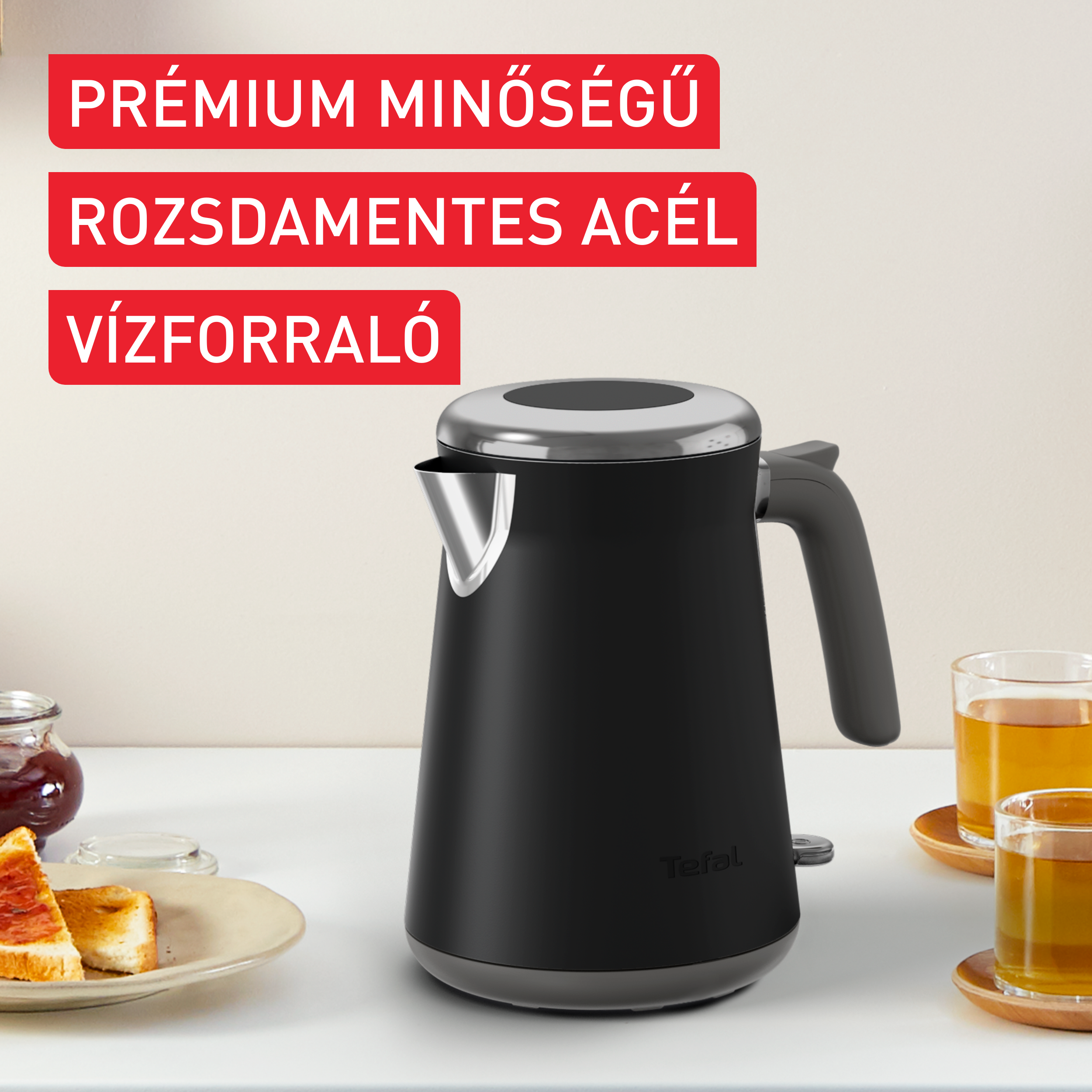 Fekete elektromos vízforraló a pulton két teáscsészével.
