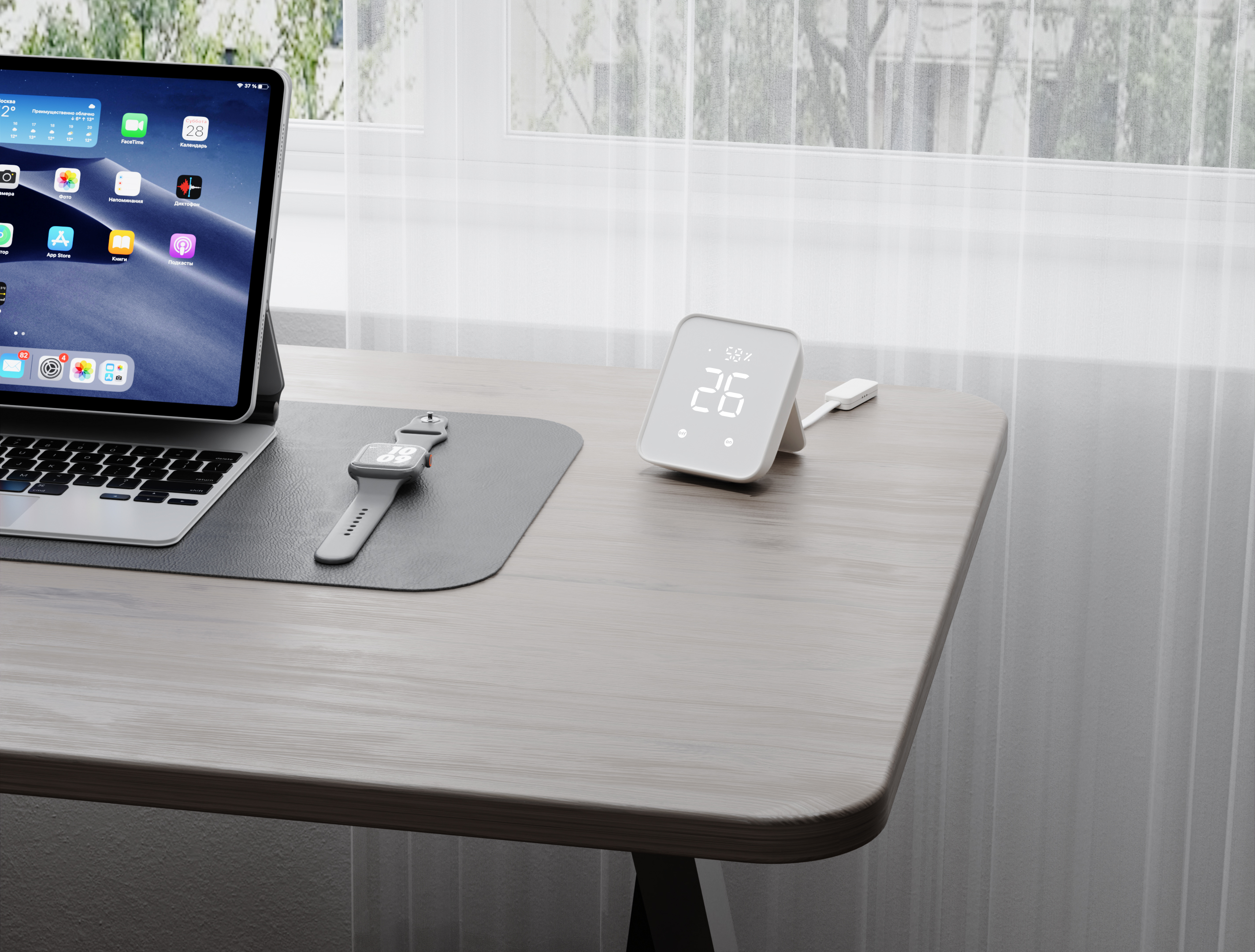 Ein weißes Smart-Gerät zeigt 26 Grad auf einem Holzschreibtisch mit Tablet und Uhr an.