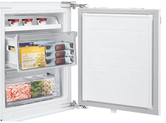 Zbliżenie zamrażarki z szeroką gamą jedzenia w środku.