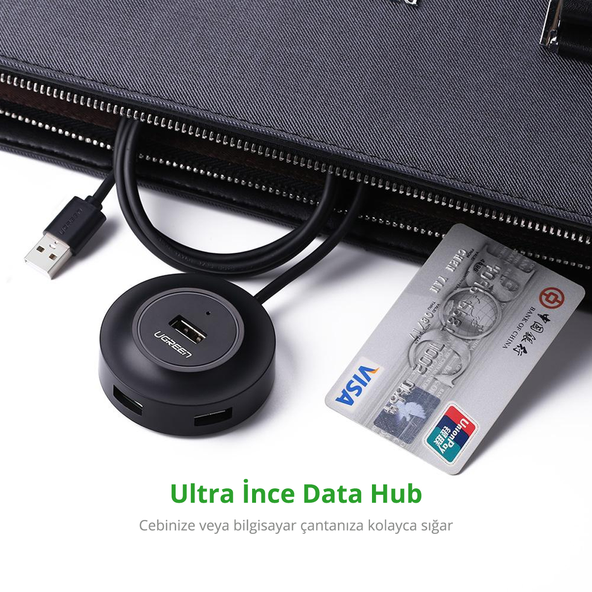 Siyah bir USB hub, kredi kartı ve siyah bir çanta beyaz bir yüzeyde. Hub'ın markası UGREEN.