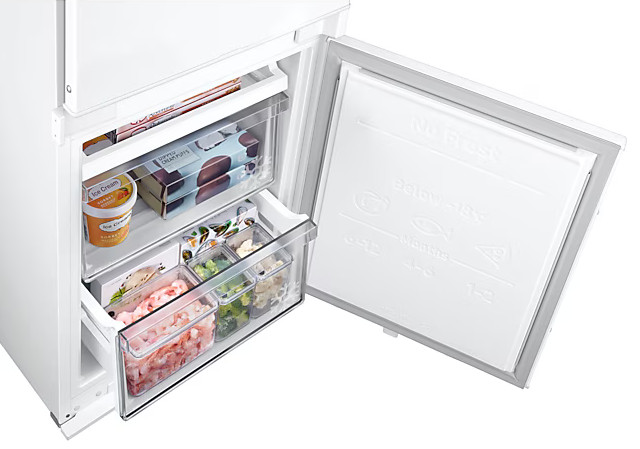 Lodówka z otwartymi drzwiami. Wewnątrz szuflady z lodami i artykułami spożywczymi.