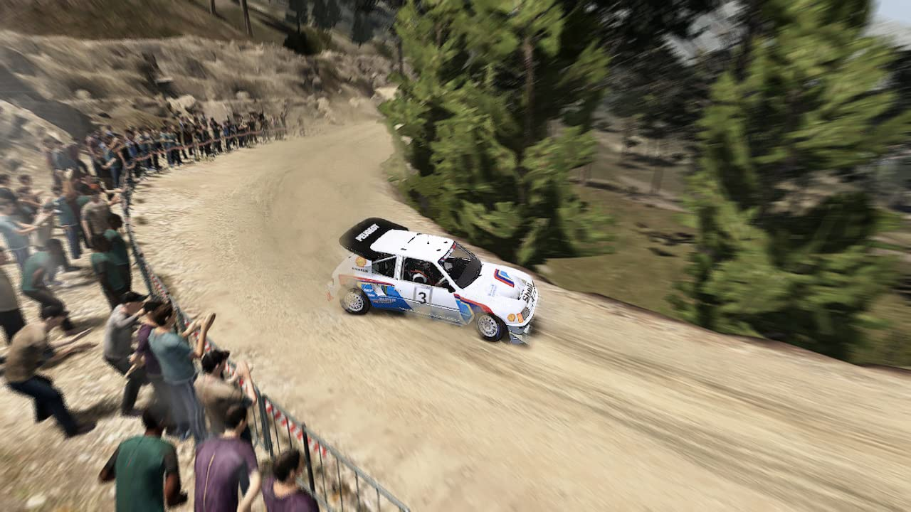 Ein Rallye-Auto, das auf einer unbefestigten Straße mit einer Menschenmenge fährt.