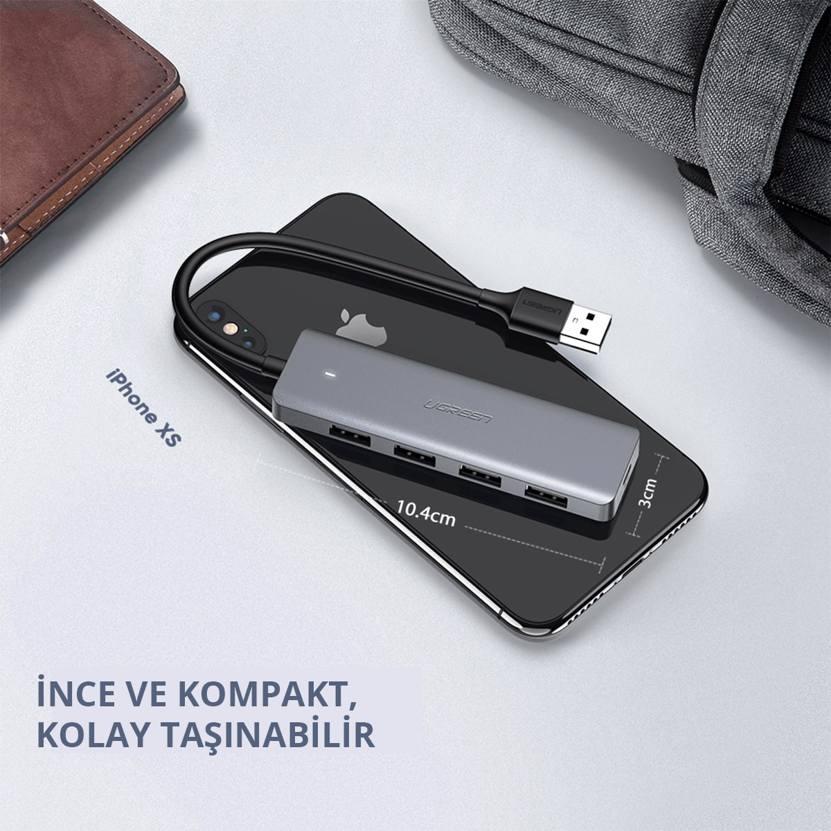 Gri USB hub iPhone XS üzerinde. Bağlantı noktaları ve kablosu var.