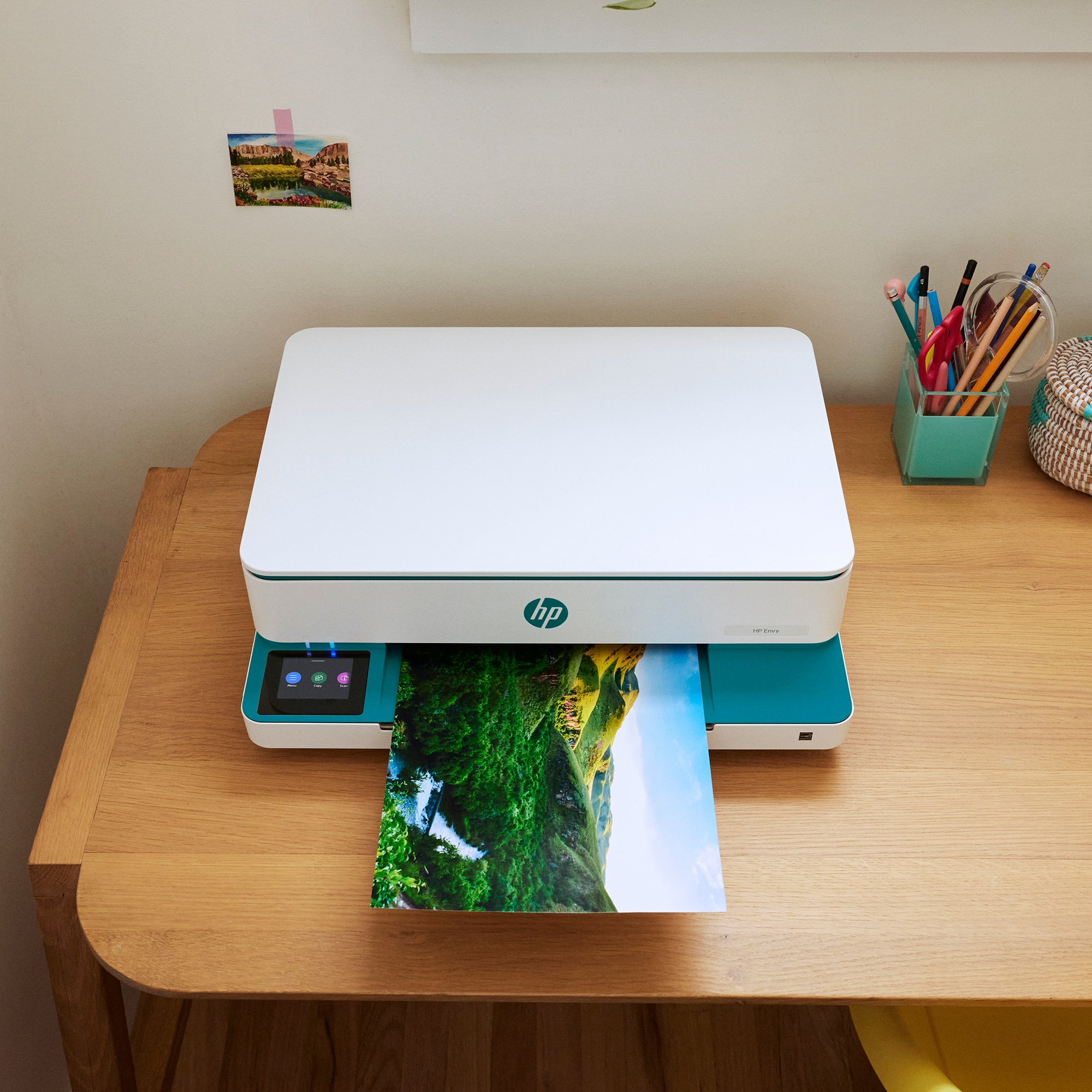 Drukarka drukująca kolorowy obrazek na drewnianym stole.