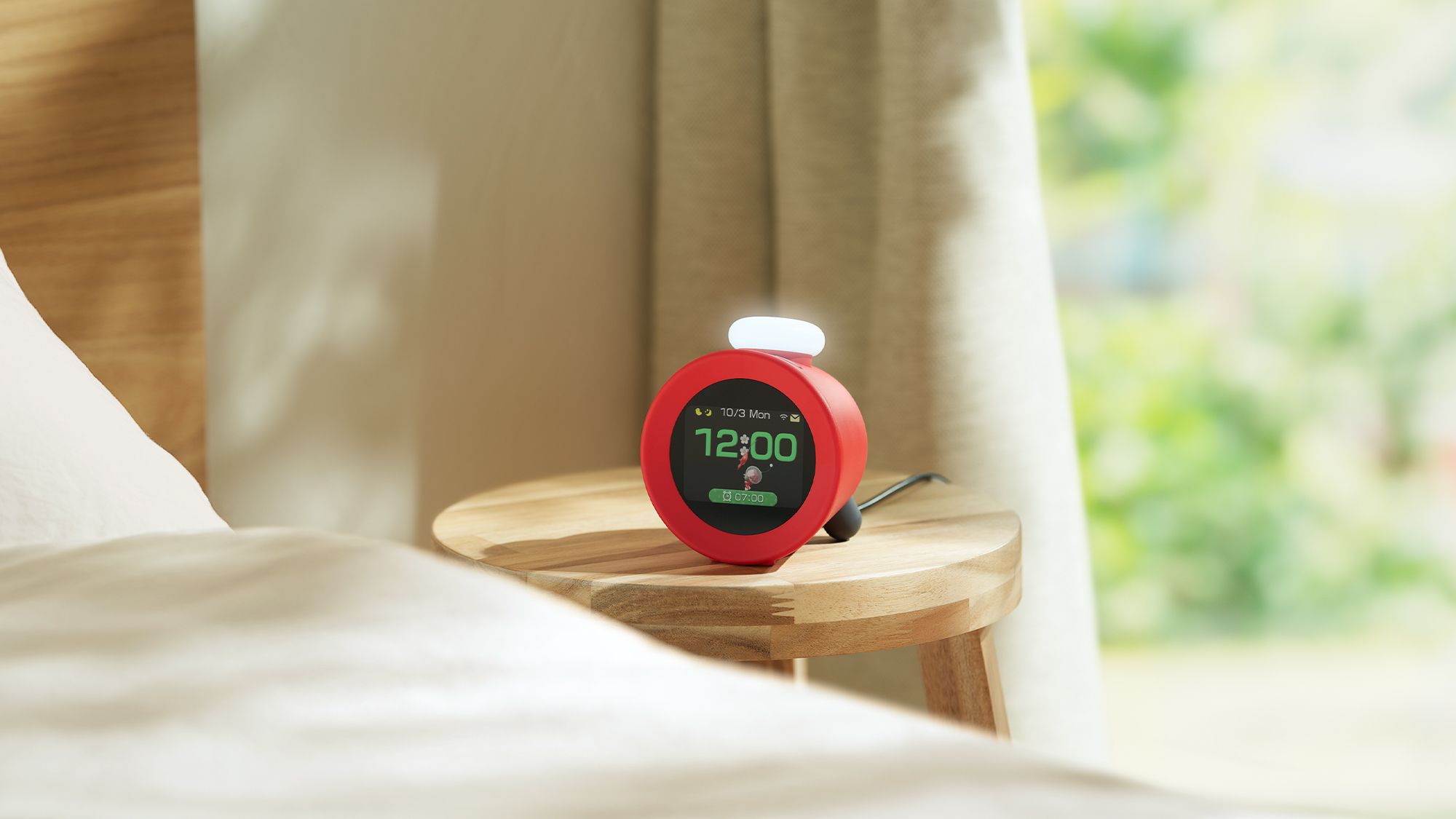 Un réveil rouge sur une petite table en bois près d'un lit. L'heure est 12h00.