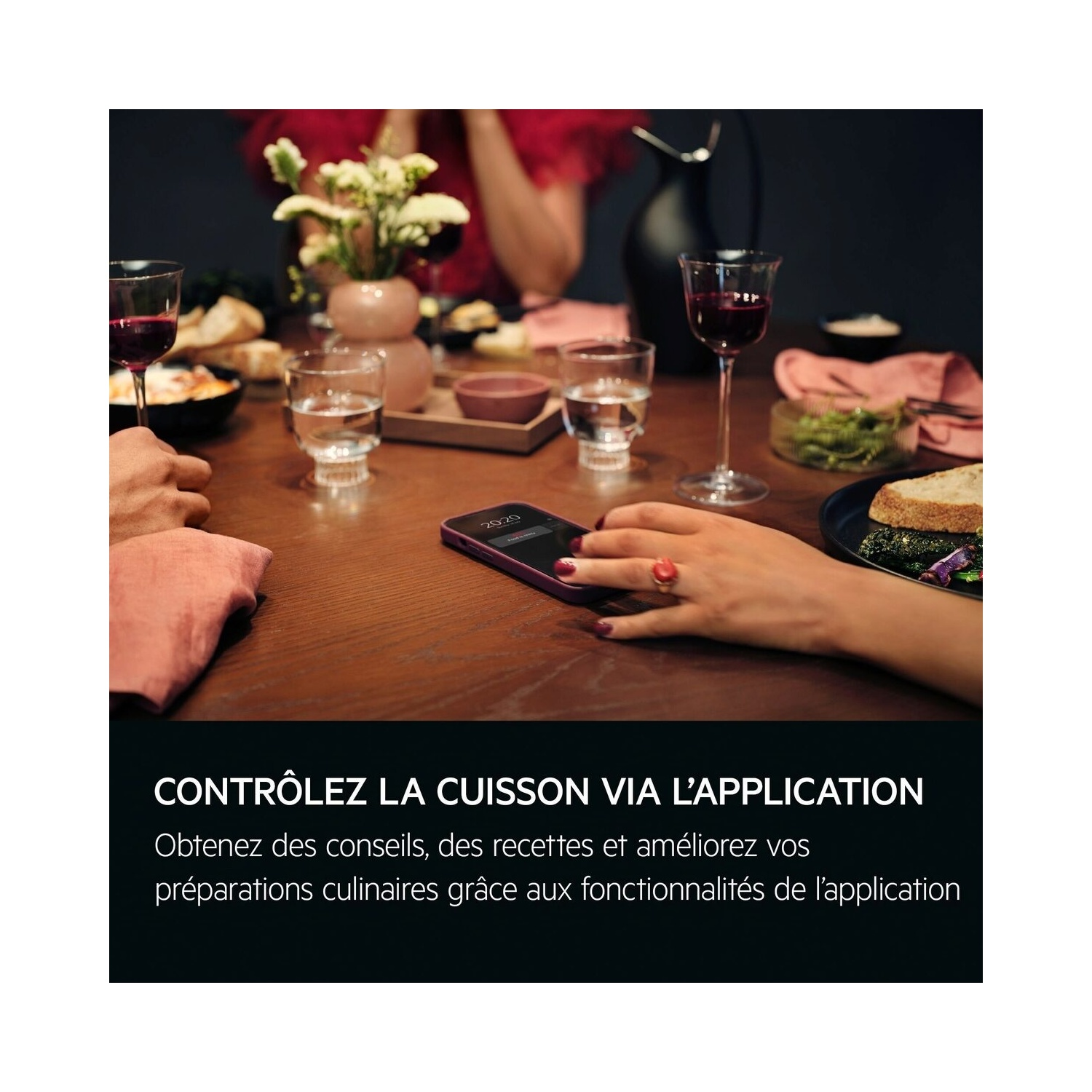 Une table avec de la nourriture et des boissons. Un téléphone est mis au point, et le texte dit : Contrôlez la cuisson via l'application.
