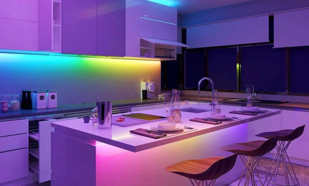 Nowoczesna kuchnia z kolorowym oświetleniem LED. Wyspa kuchenna z hokerami.