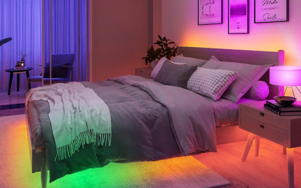 Nowoczesna sypialnia z kolorowymi listwami świetlnymi LED. Widoczne są łóżko, szafka nocna i dzieła sztuki.