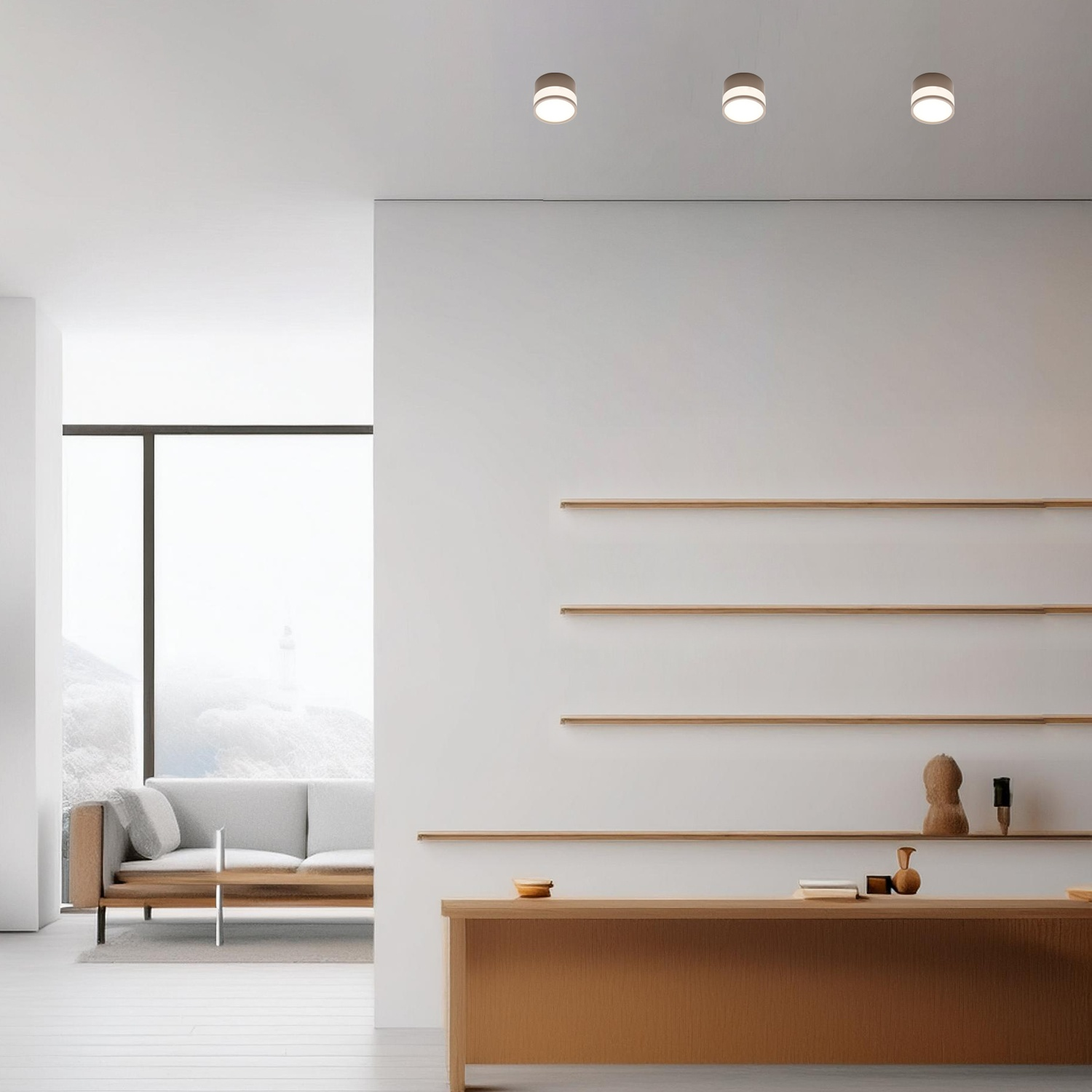 Soggiorno moderno con pareti bianche, divano, tavolo e tre luci a soffitto. Una finestra mostra montagne innevate.